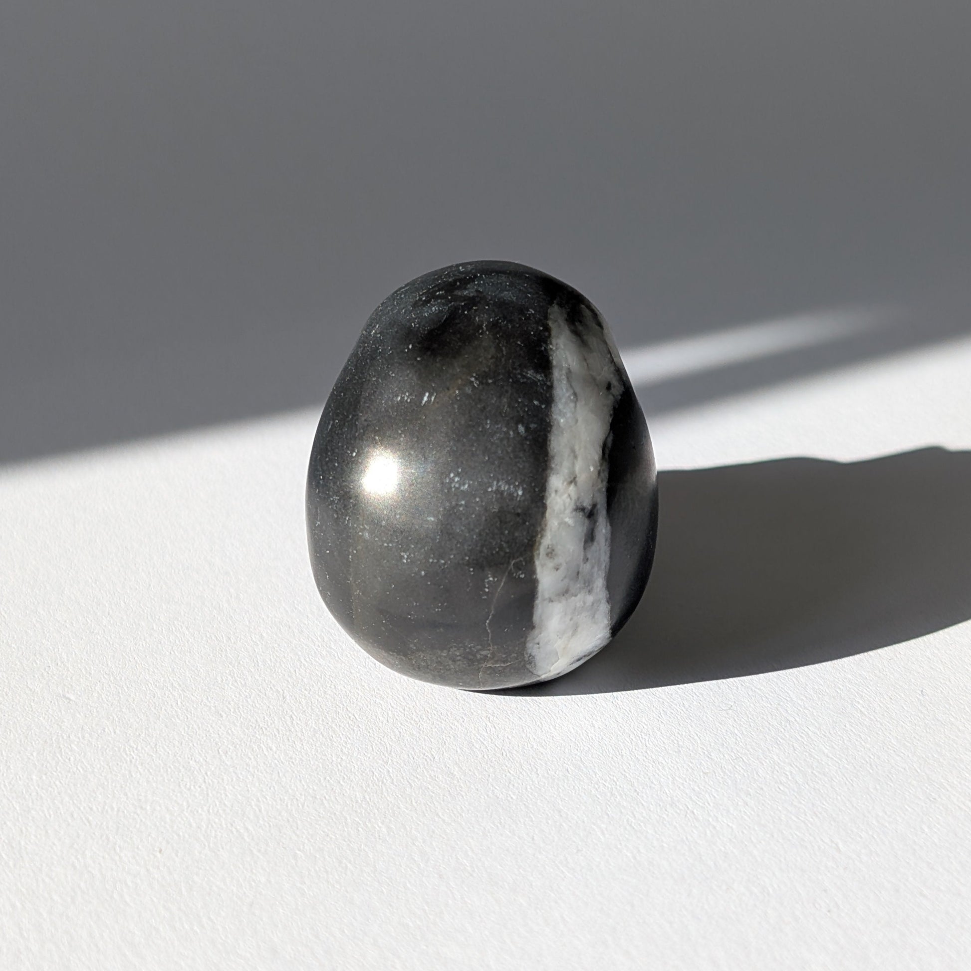 Kleiner Kristallschädel "Adagoi" (115g) aus schwarz-weiß gemustertem Kalkstein/Marmor.