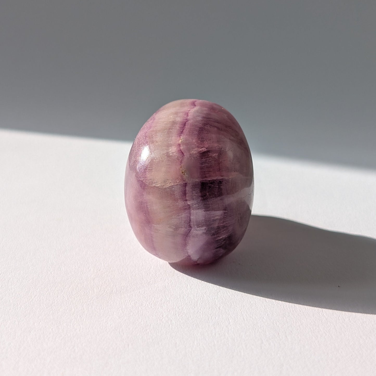 Kleiner Kristallschädel "Boron" (99g) aus klar gebändertem violett-weißem Fluorit.