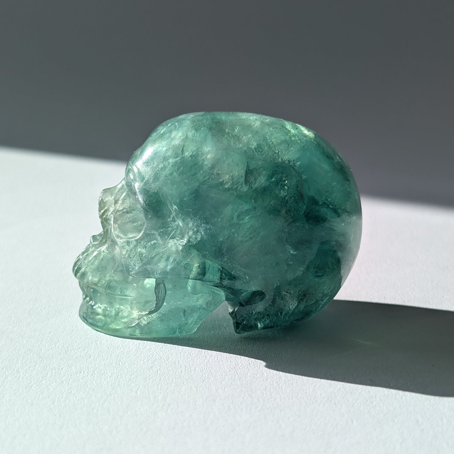 Kleiner Kristallschädel "Buros" (98g) aus klar gebändertem violett-weißem Fluorit.