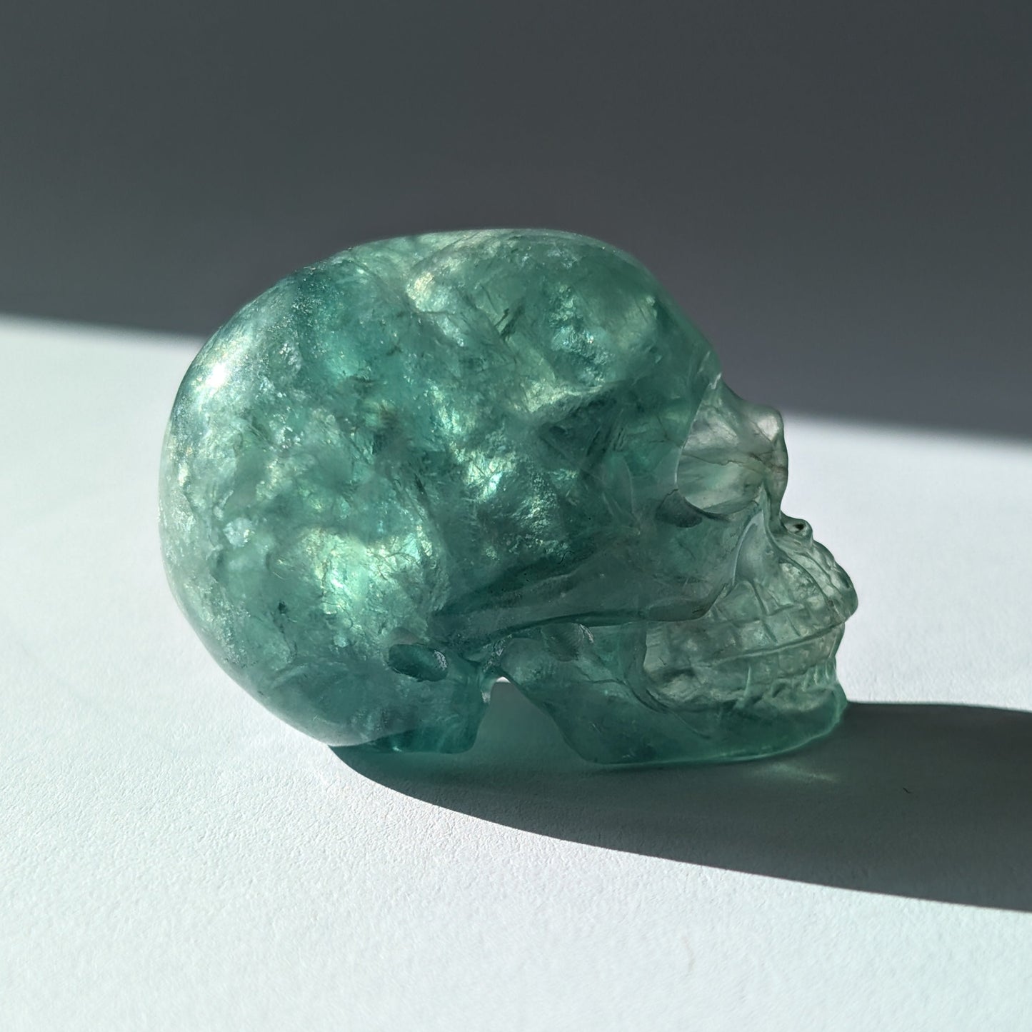 Kleiner Kristallschädel "Buros" (98g) aus klar gebändertem violett-weißem Fluorit.