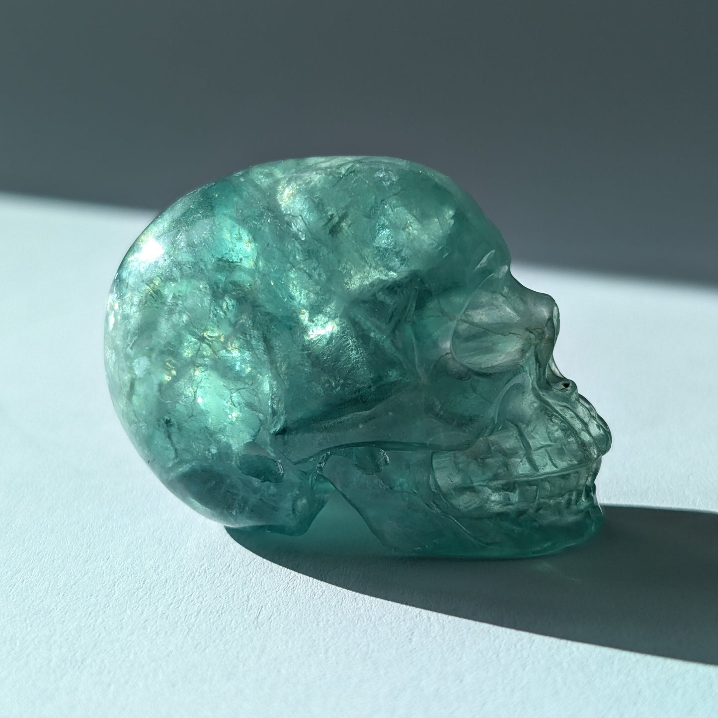 Kleiner Kristallschädel "Buros" (98g) aus klar gebändertem violett-weißem Fluorit.