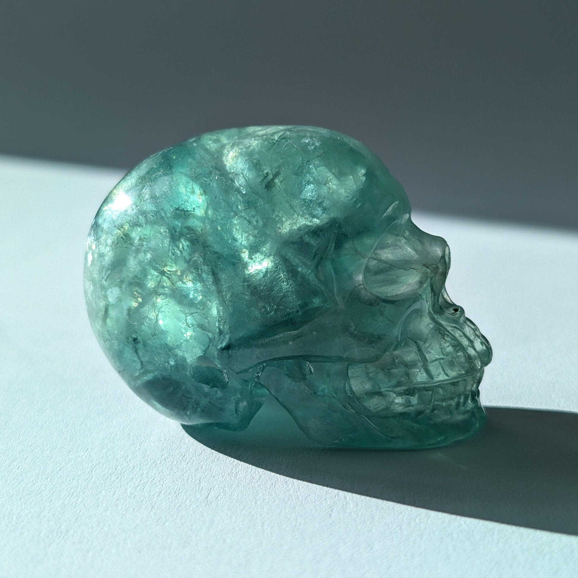 Kleiner Kristallschädel "Buros" (98g) aus klar gebändertem violett-weißem Fluorit.