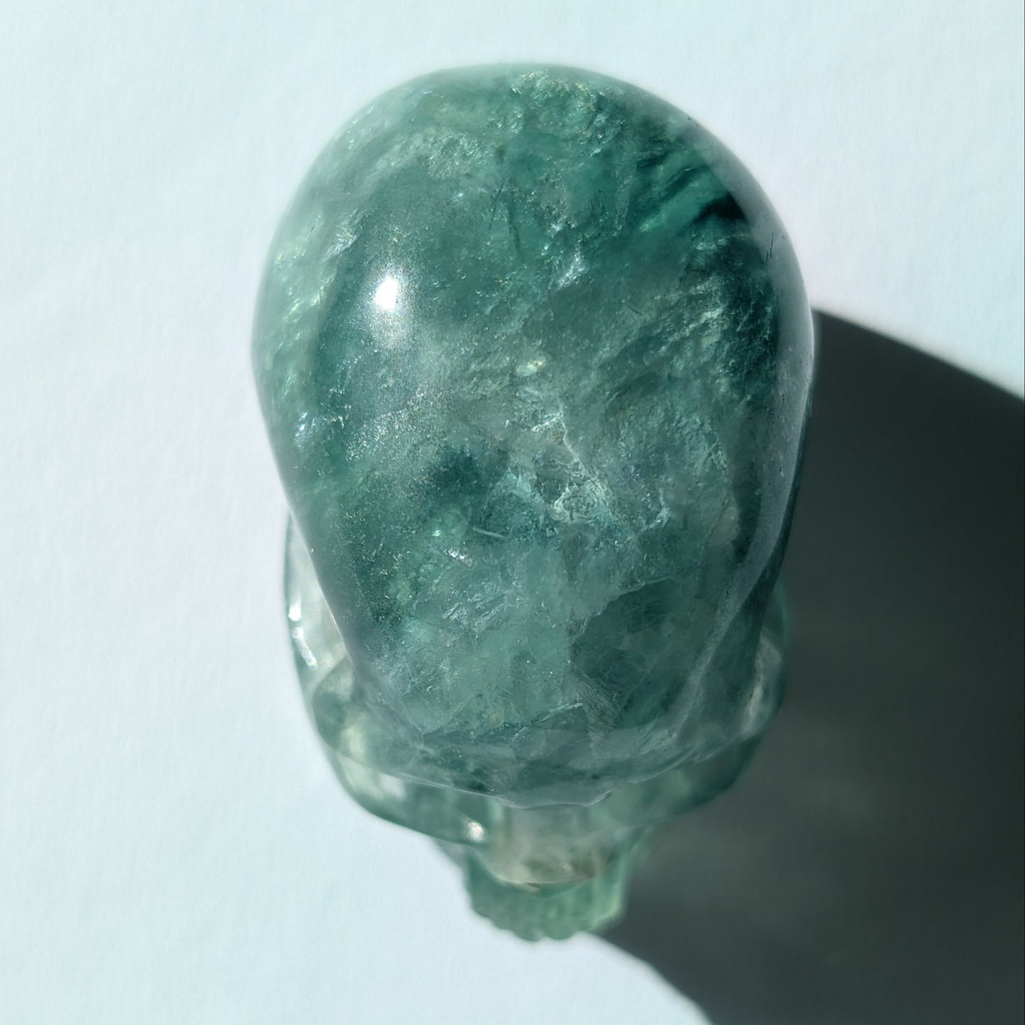 Kleiner Kristallschädel "Buros" (98g) aus klar gebändertem violett-weißem Fluorit.