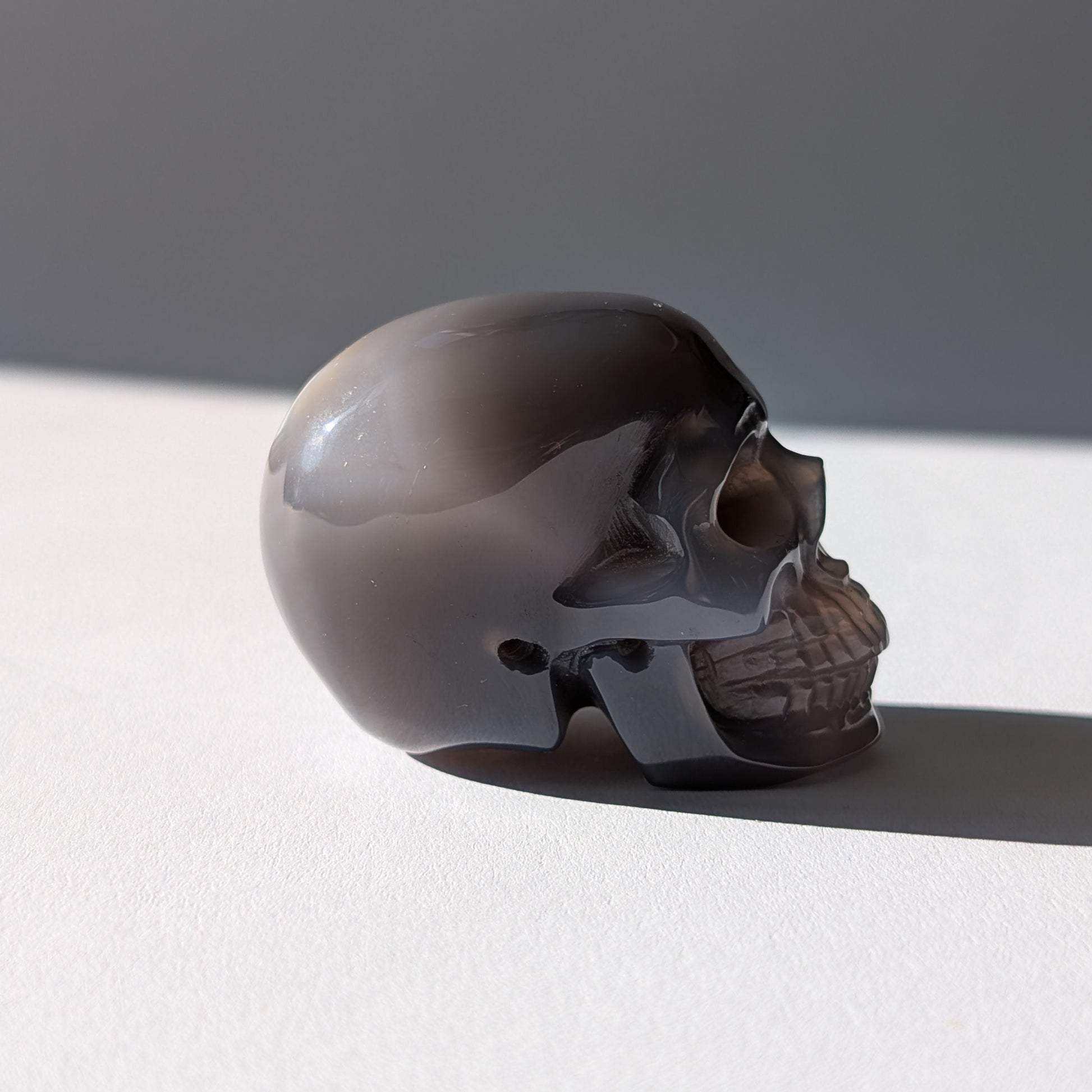 Kleiner Kristallschädel "Colan" (85g) aus grau-weiß gebändertem Botswana Achat.