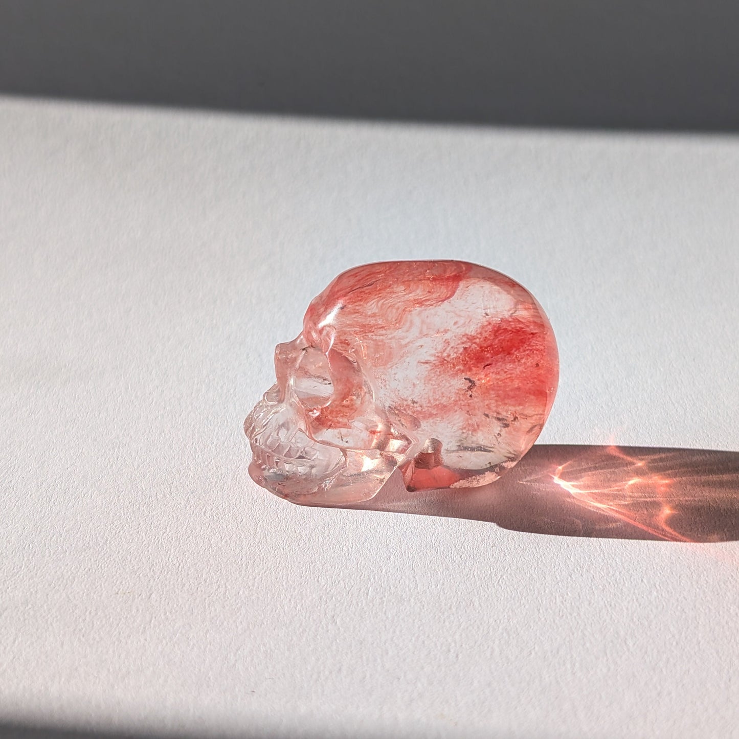 Kleiner Kristallschädel "Elder" (70g) aus leuchtend rosa-rotem Kirschquarz.