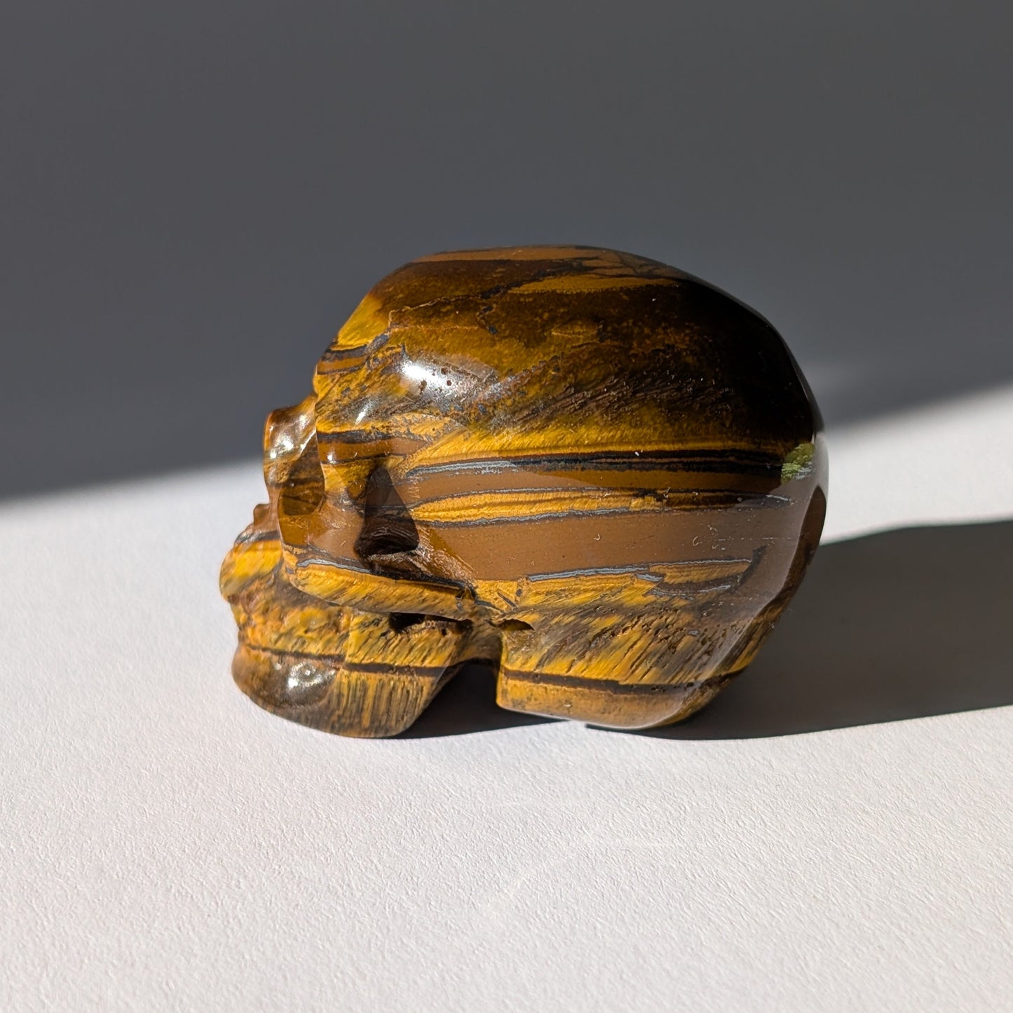 Kleiner Kristallschädel "Gonthar" (95g) aus gebändertem Tigereisen (Tigerauge, Hämatit, Jaspis).