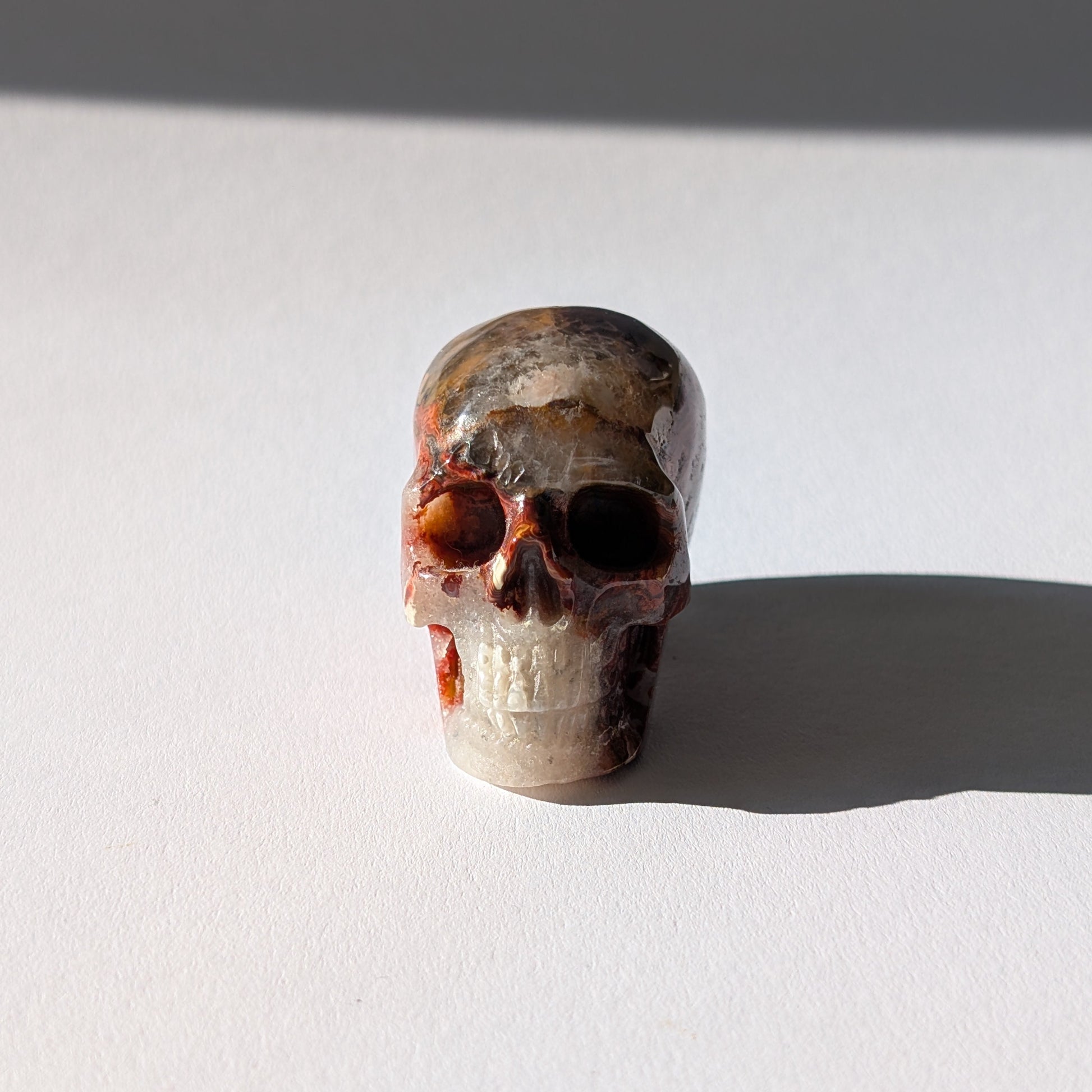 Kleiner Kristallschädel "Marjaana" (79g) aus bunt gebändertem Crazy Lace Achat.