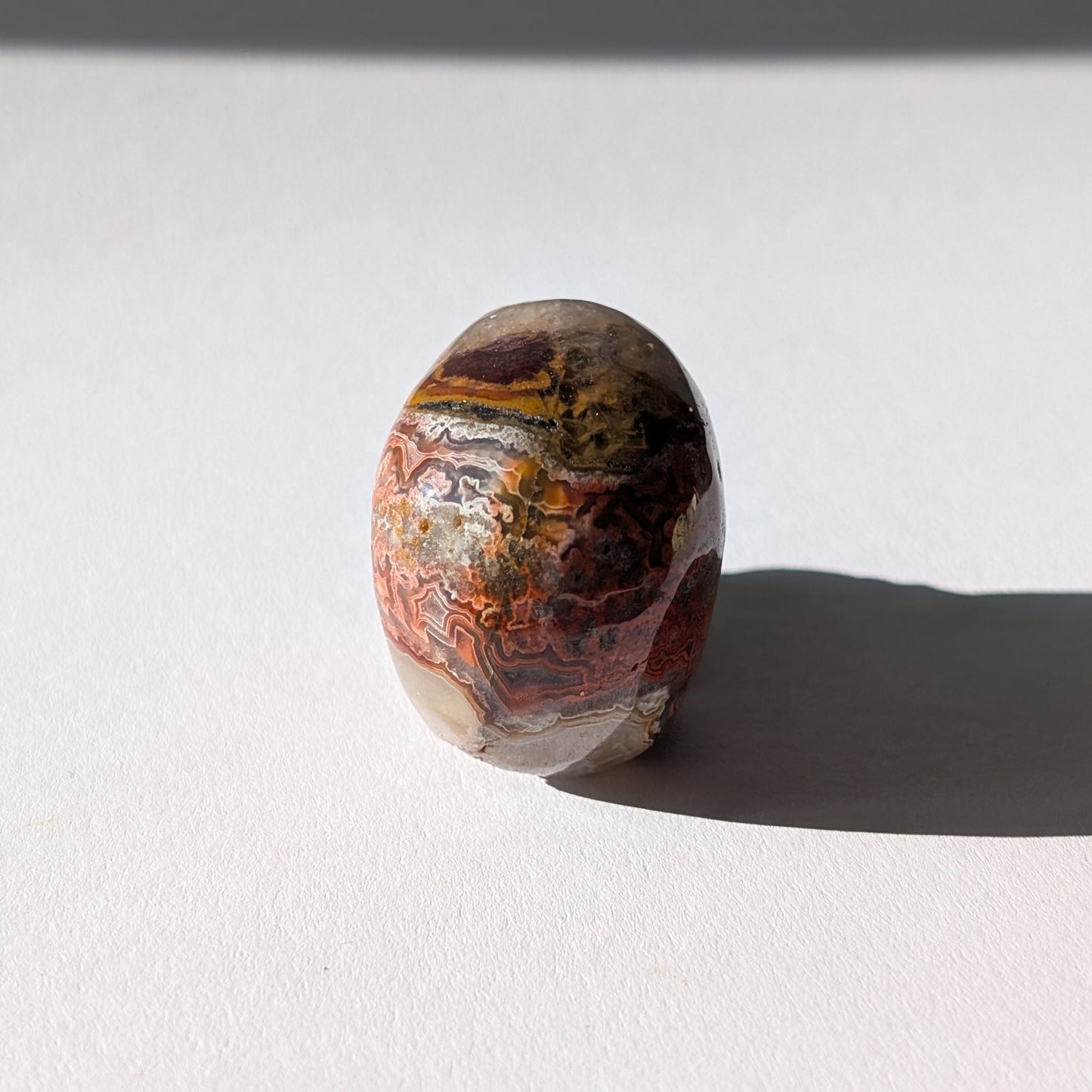 Kleiner Kristallschädel "Marjaana" (79g) aus bunt gebändertem Crazy Lace Achat.