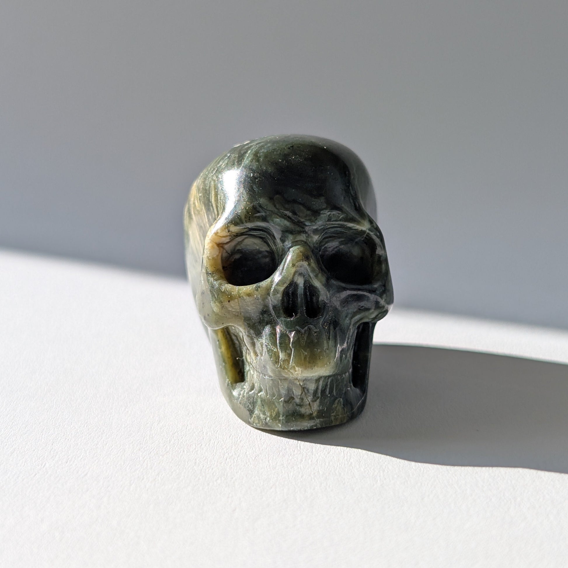 Kleiner Kristallschädel "Obak" (78g) aus dunkelgrün gemustertem Serpentin.