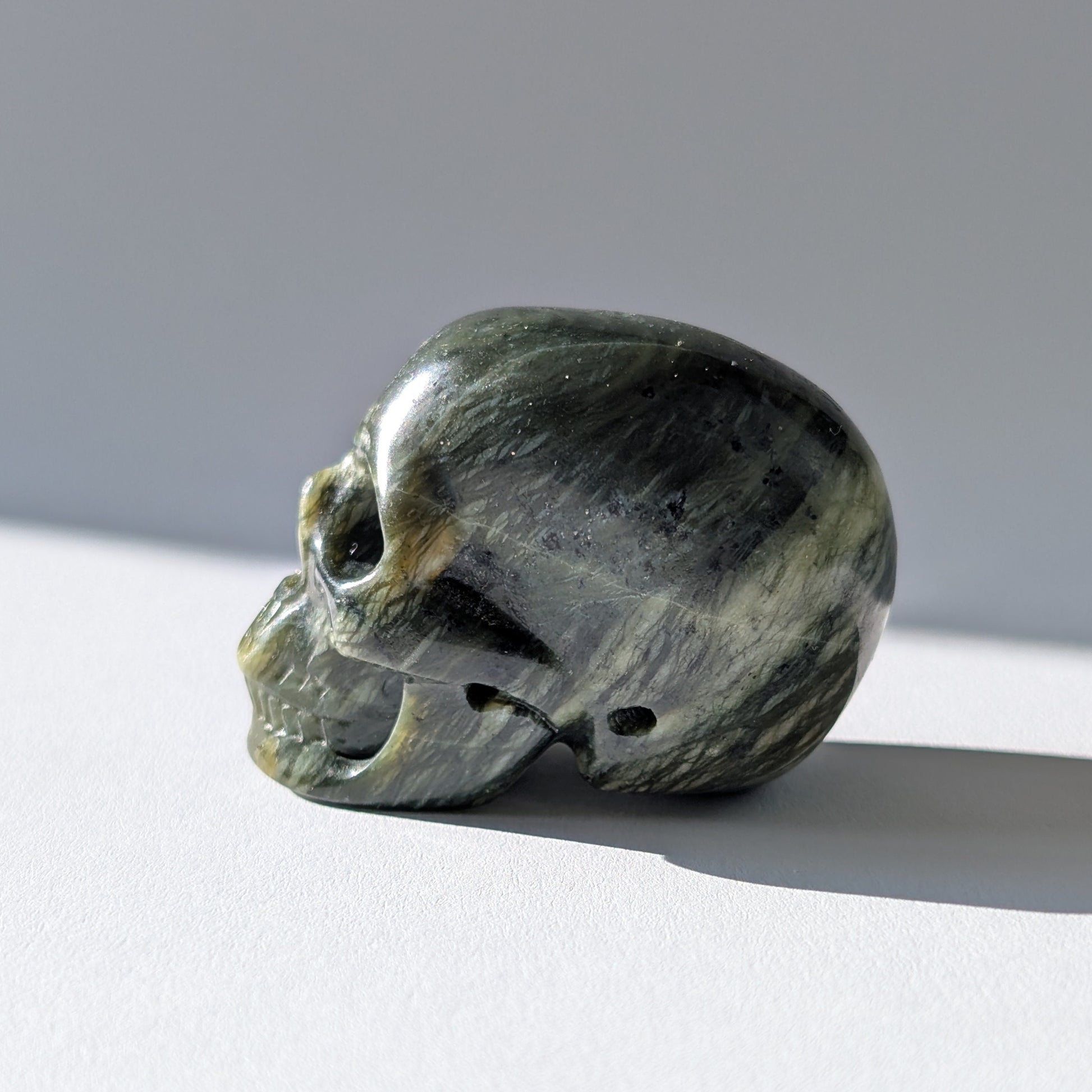 Kleiner Kristallschädel "Obak" (78g) aus dunkelgrün gemustertem Serpentin.