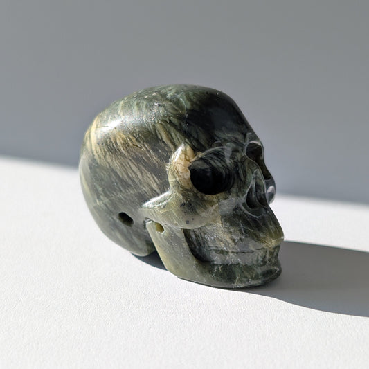 Kleiner Kristallschädel "Obak" (78g) aus dunkelgrün gemustertem Serpentin.