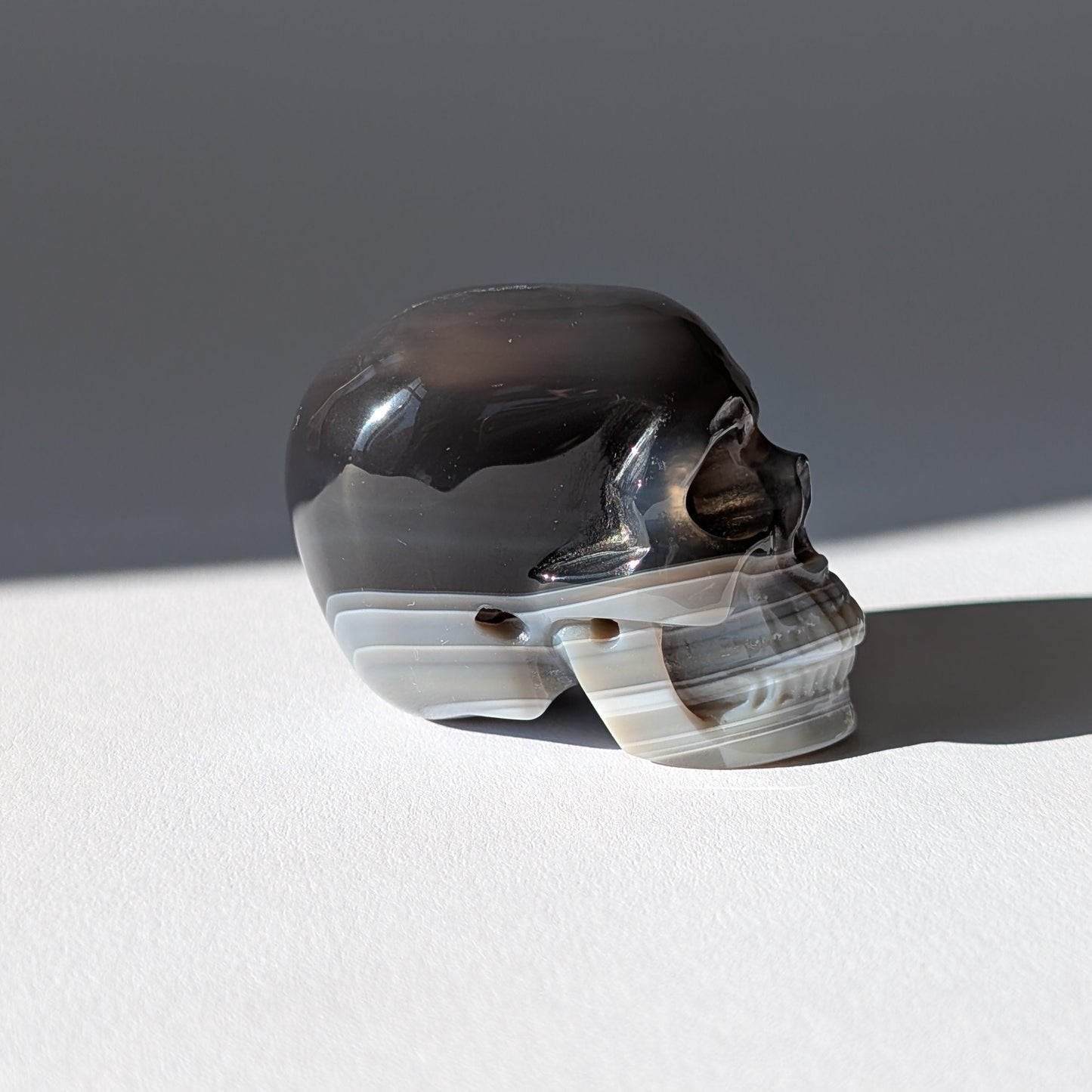 Kleiner Kristallschädel "Yura" (84g) aus schwarz-weiß gebändertem Achat.