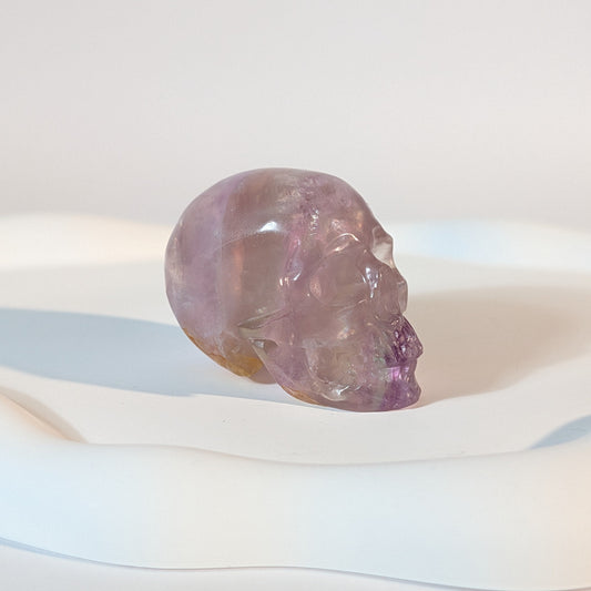 Kompakter Kristallschädel Teitur aus durchscheinendem, violettem Fluorit mit sanften inneren Strukturen.