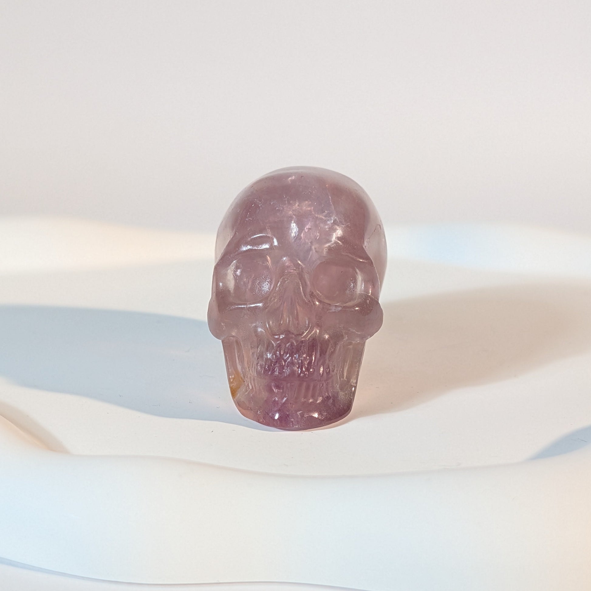 Kompakter Kristallschädel Teitur aus durchscheinendem, violettem Fluorit mit sanften inneren Strukturen.