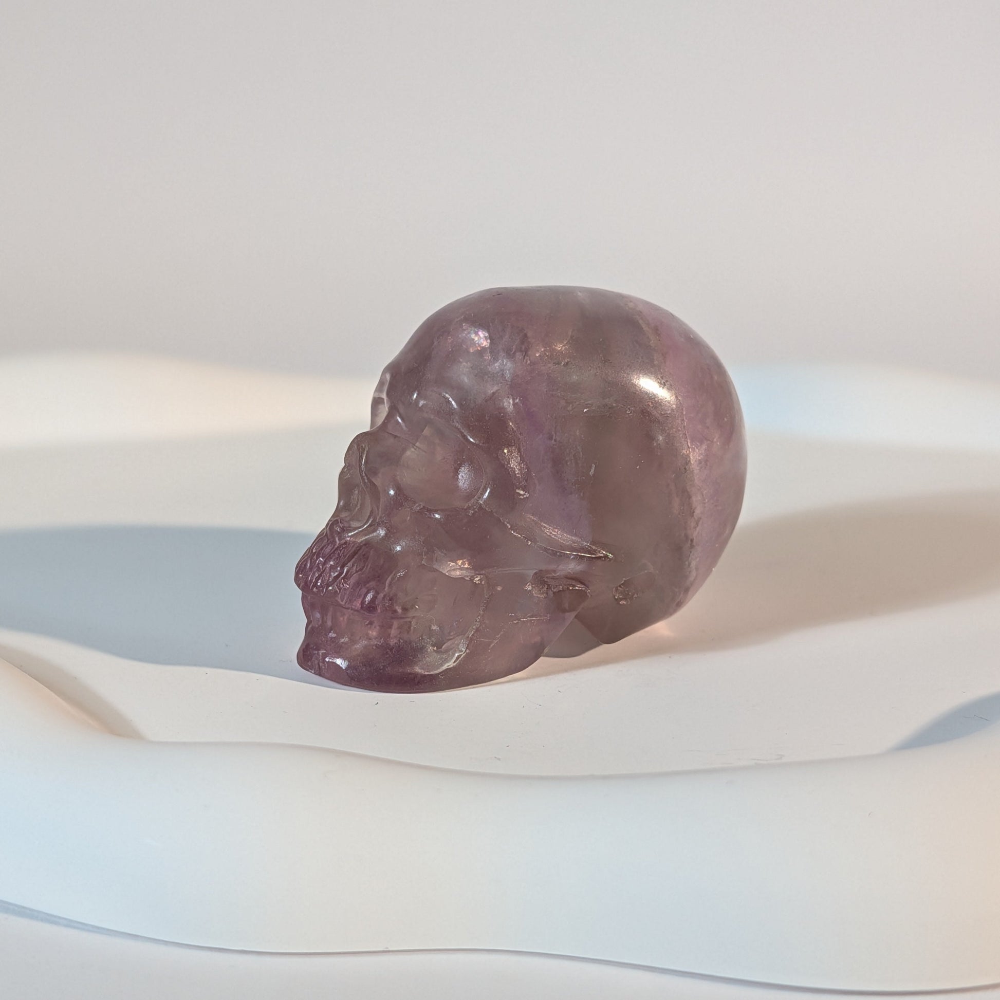 Kompakter Kristallschädel Teitur aus durchscheinendem, violettem Fluorit mit sanften inneren Strukturen.