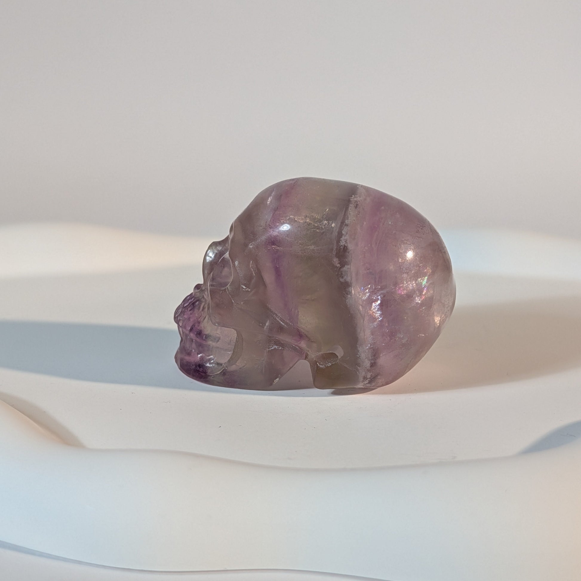 Kompakter Kristallschädel Teitur aus durchscheinendem, violettem Fluorit mit sanften inneren Strukturen.