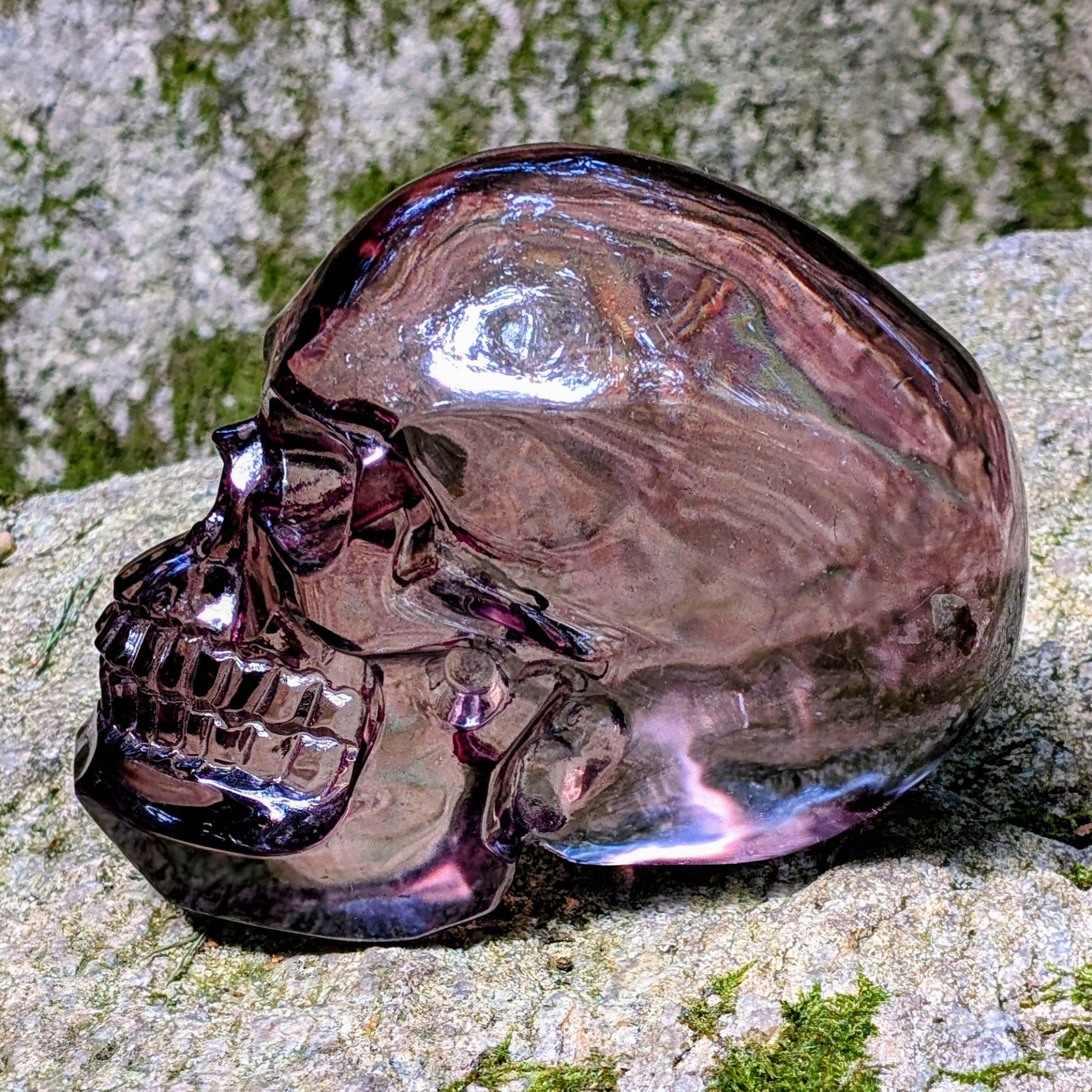 Kristallschädel "Aura-Seele" aus Aura-Glas mit rauchig-violetten Reflexen.