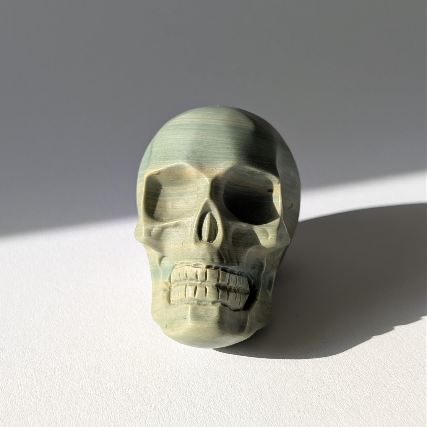 Kristallschädel "Brynjolf" (204g) aus sanft grün gebändertem Ozean Jaspis.