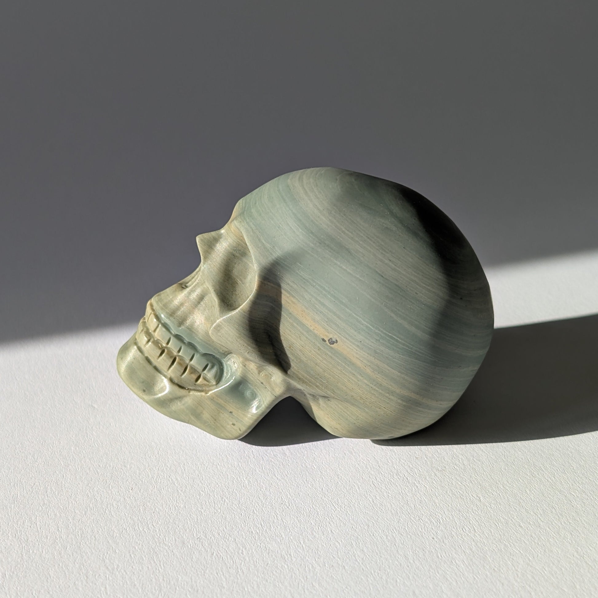 Kristallschädel "Brynjolf" (204g) aus sanft grün gebändertem Ozean Jaspis.