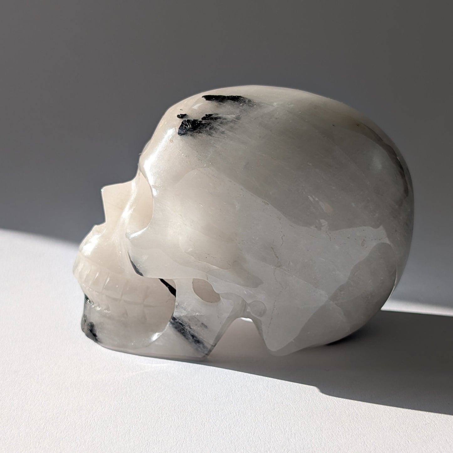 Kristallschädel "Cornelius" (645g) aus Quarz mit vielen schwarzen Turmalin-Nadeln.