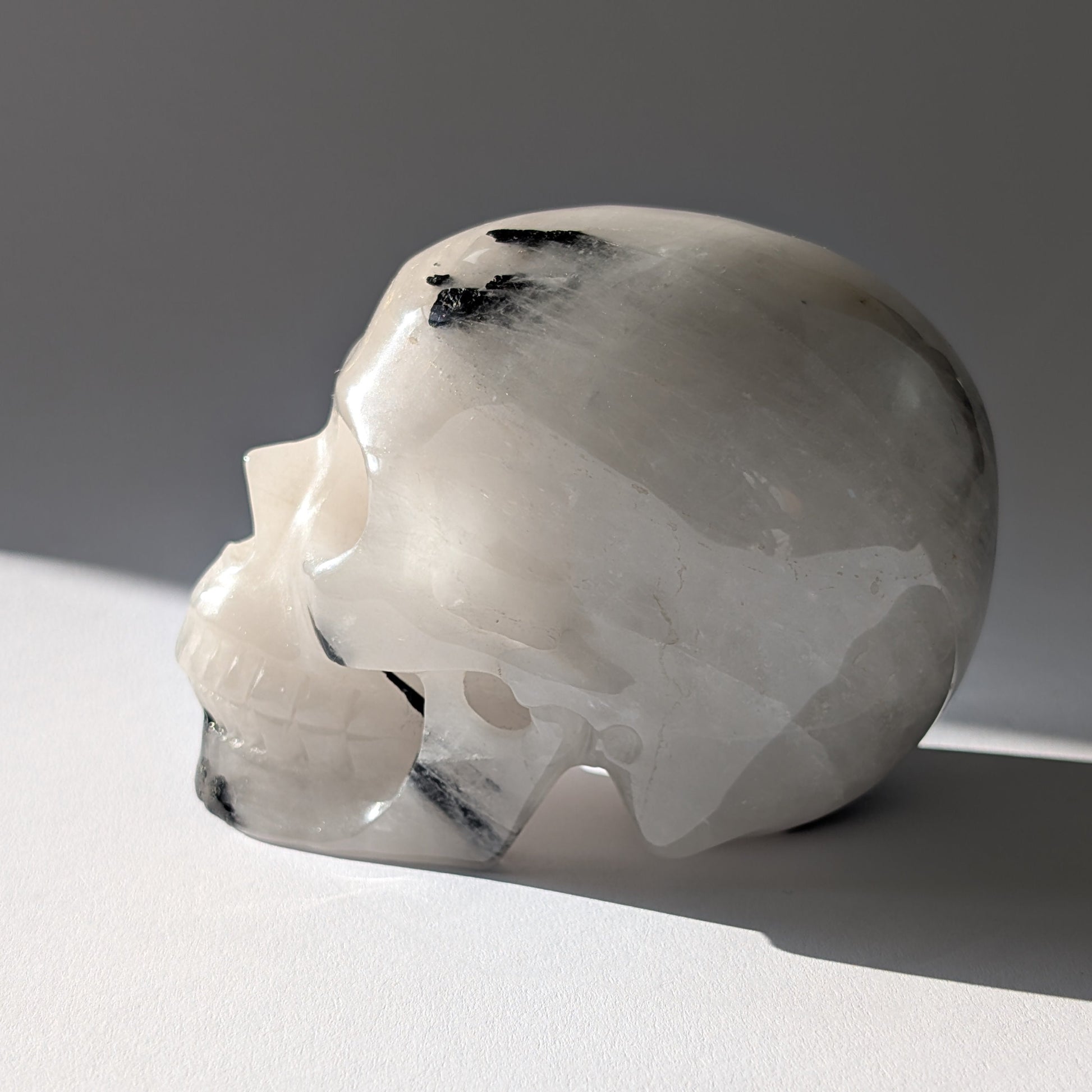 Kristallschädel "Cornelius" (645g) aus Quarz mit vielen schwarzen Turmalin-Nadeln.