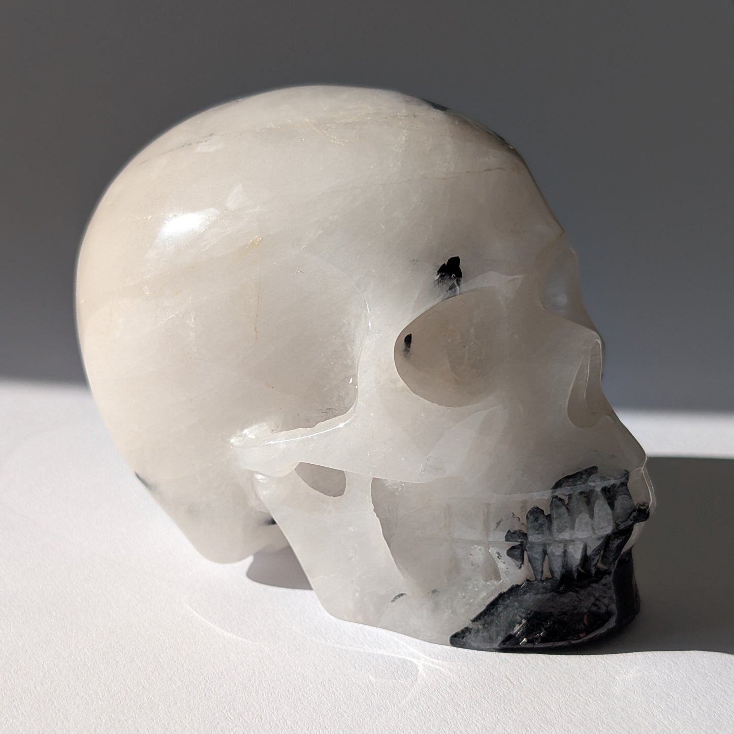 Kristallschädel "Cornelius" (645g) aus Quarz mit vielen schwarzen Turmalin-Nadeln.