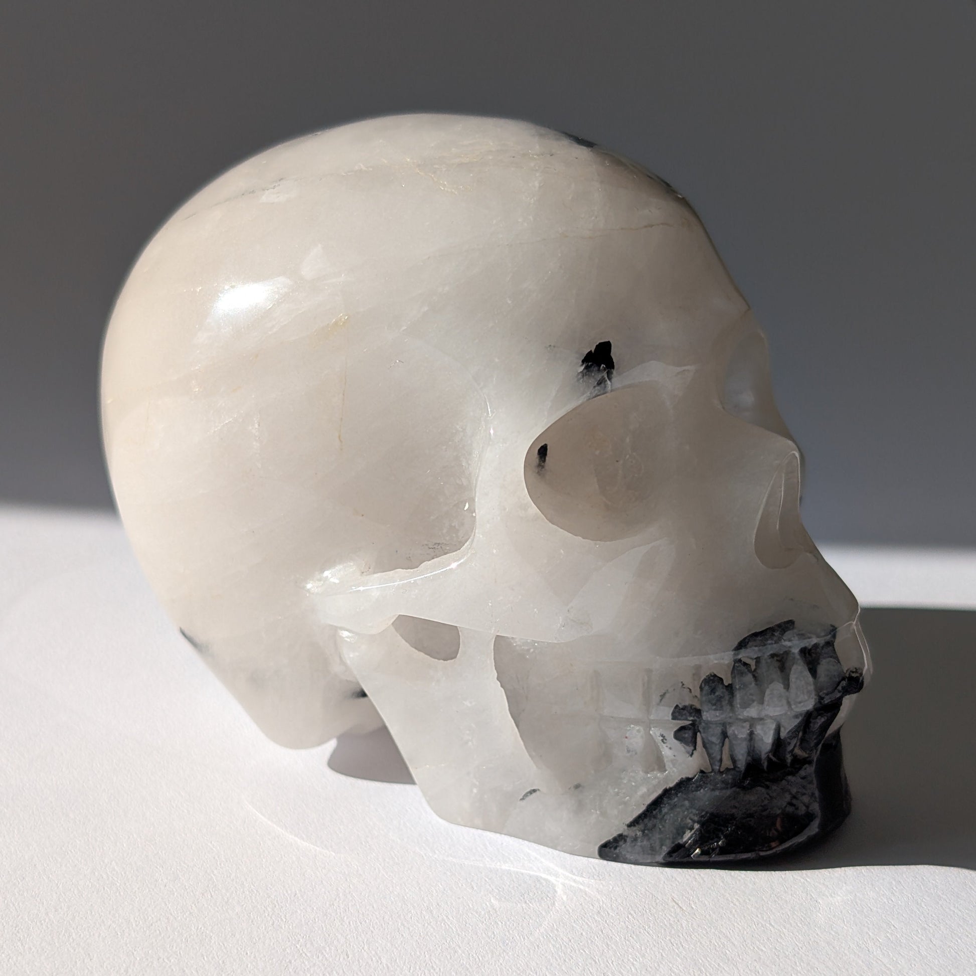 Kristallschädel "Cornelius" (645g) aus Quarz mit vielen schwarzen Turmalin-Nadeln.