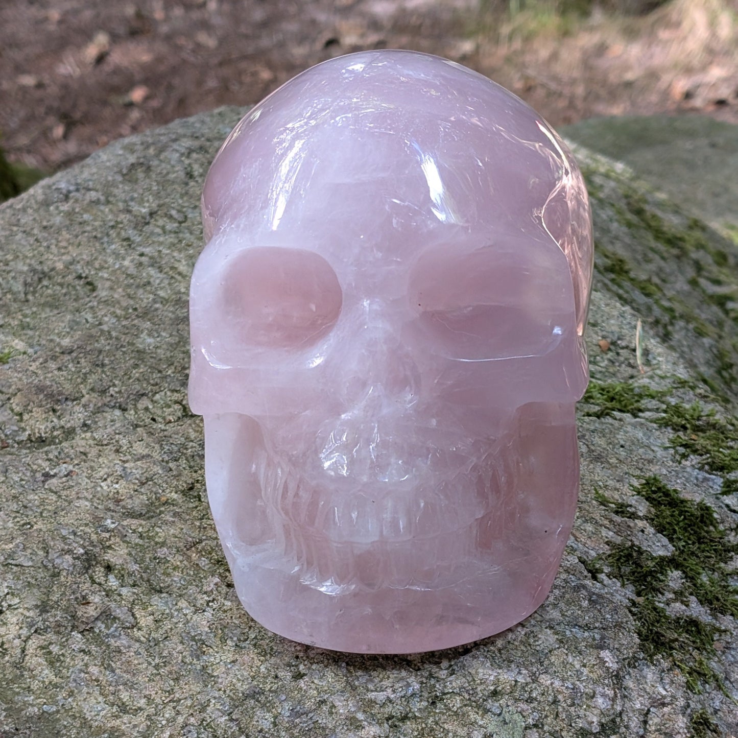 Kristallschädel "Elara" aus milchig-rosa Rosenquarz mit inneren Regenbogen-Einschlüssen.
