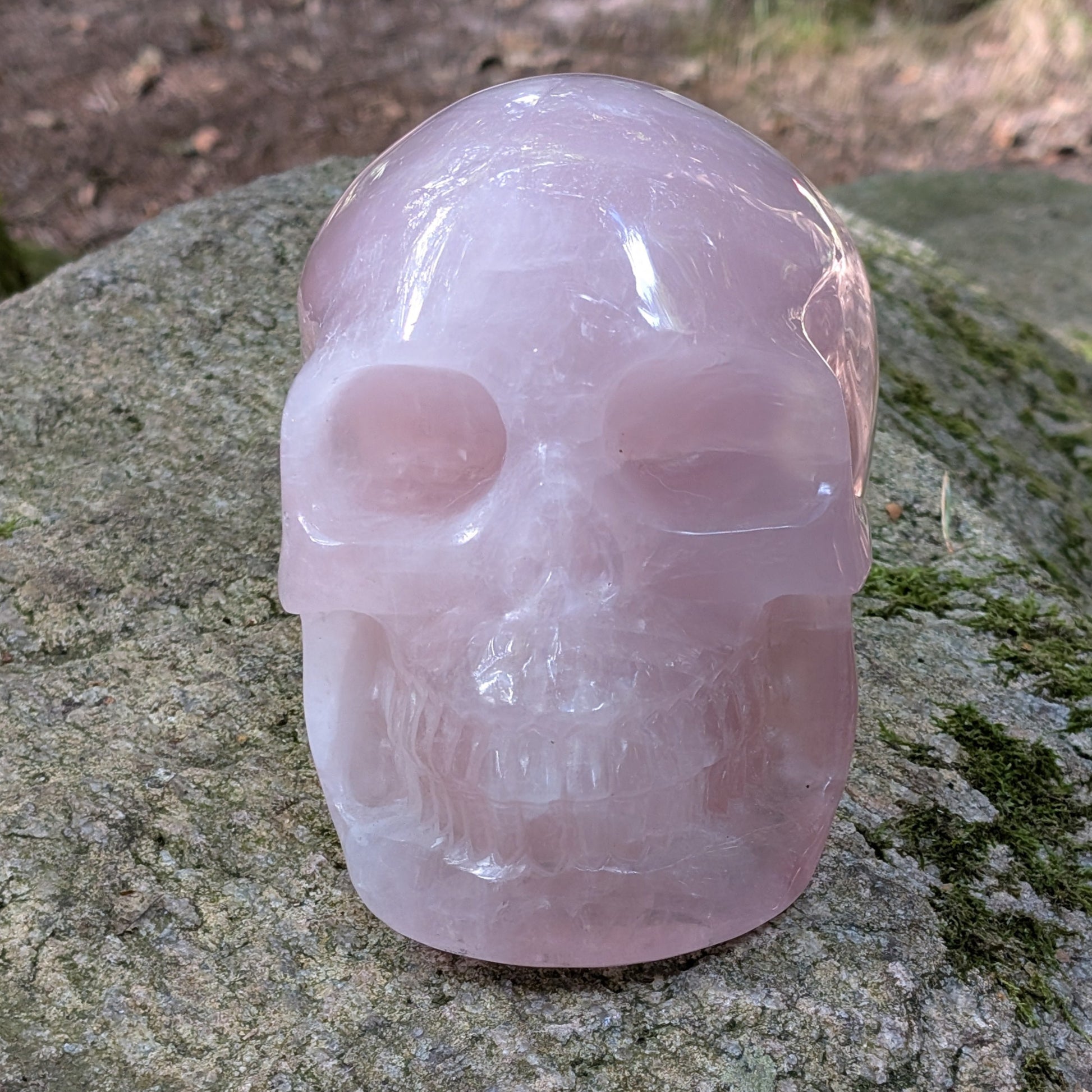 Kristallschädel "Elara" aus milchig-rosa Rosenquarz mit inneren Regenbogen-Einschlüssen.