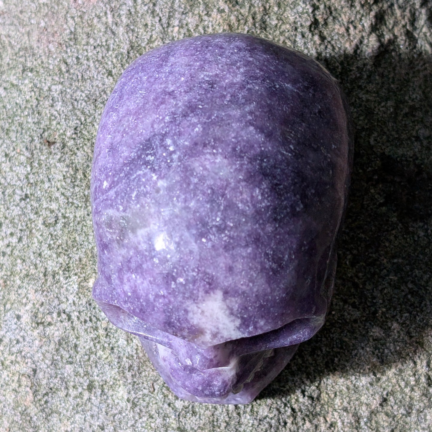 Kristallschädel "Friedenswächter" aus lila Lepidolith mit schimmernden Einschlüssen.