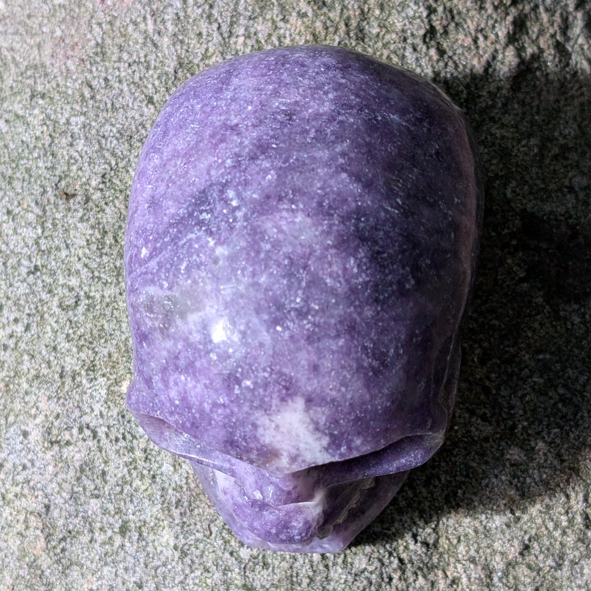 Kristallschädel "Friedenswächter" aus lila Lepidolith mit schimmernden Einschlüssen.