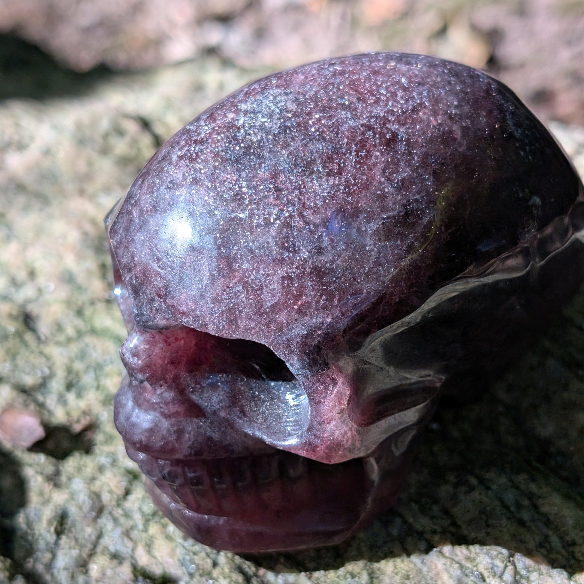 Kristallschädel "Glitzerherz" aus rosa-violettem Erdbeerquarz mit funkelnden Einschlüssen.