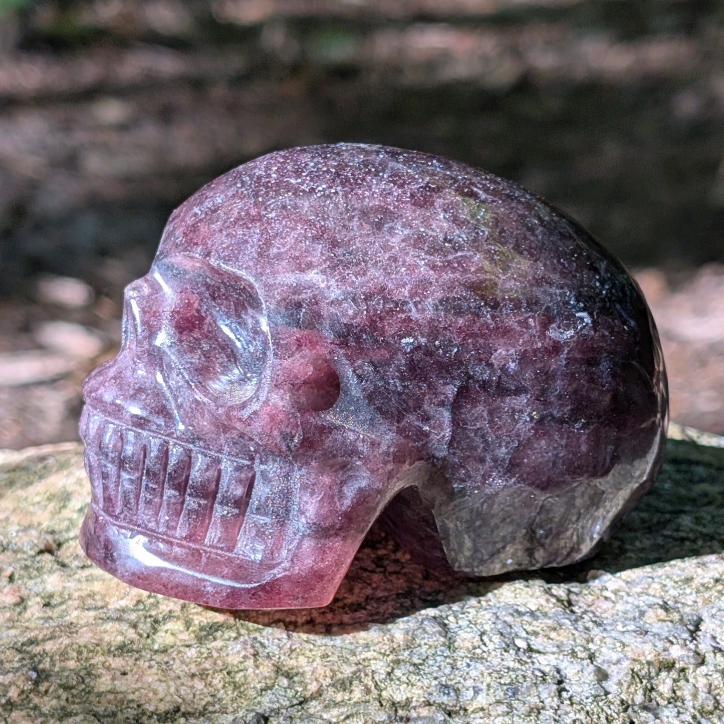 Kristallschädel "Glitzerherz" aus rosa-violettem Erdbeerquarz mit funkelnden Einschlüssen.