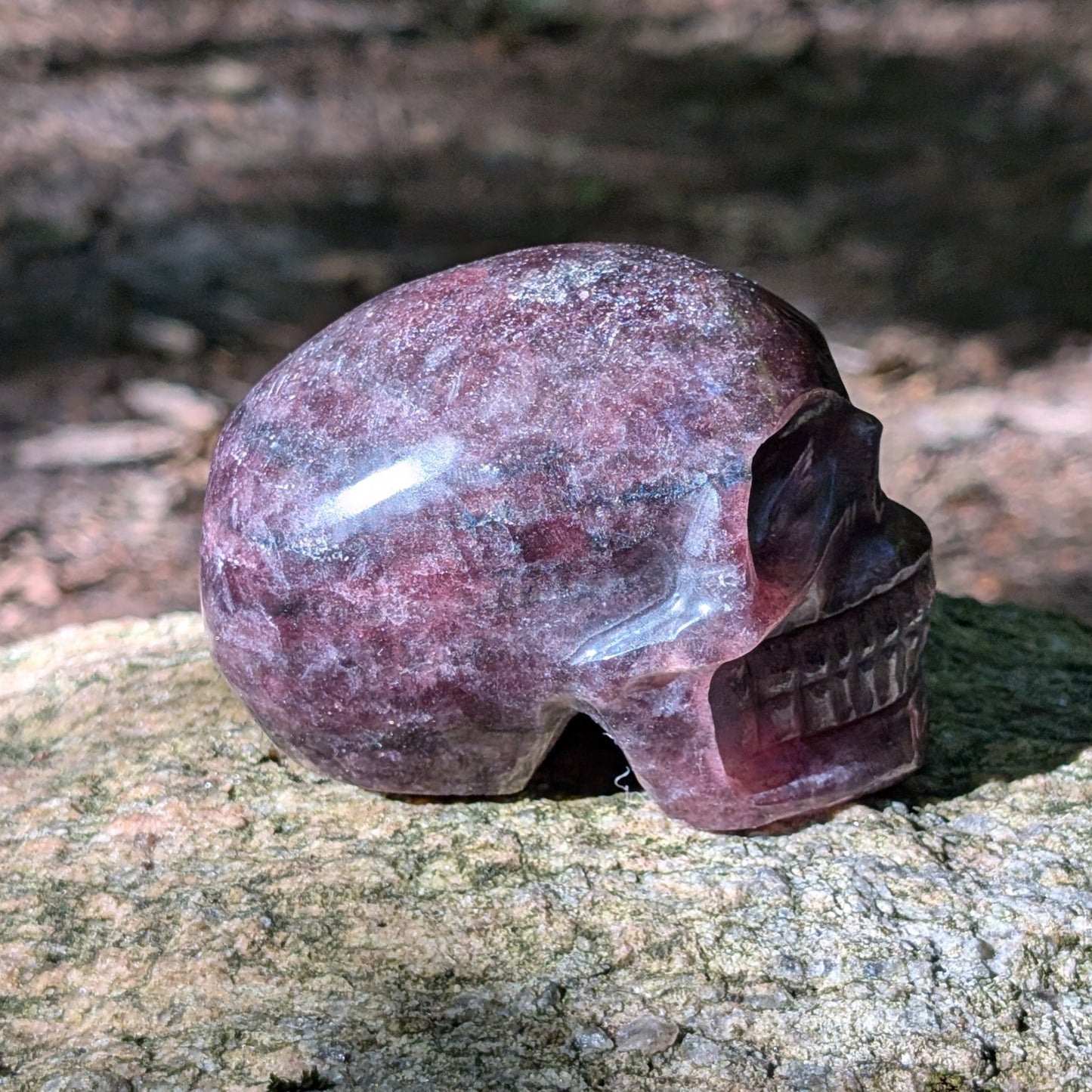 Kristallschädel "Glitzerherz" aus rosa-violettem Erdbeerquarz mit funkelnden Einschlüssen.