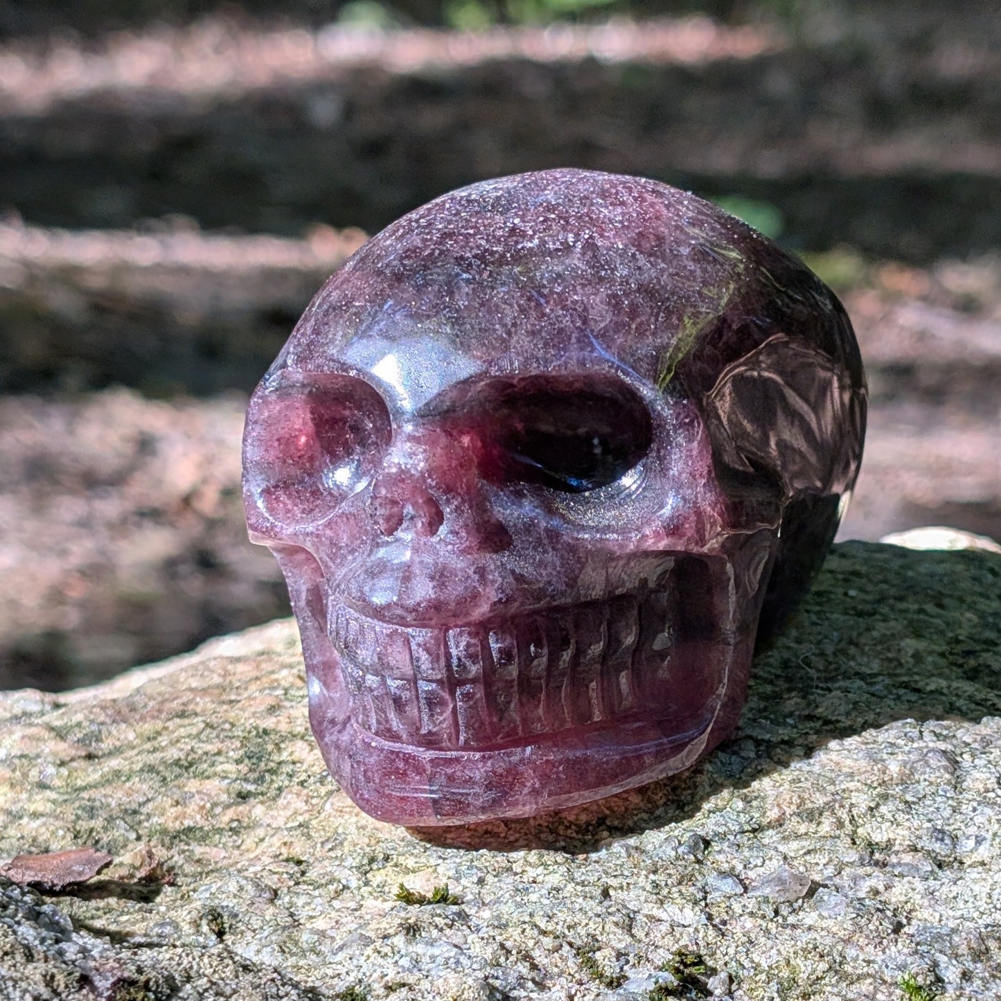 Kristallschädel "Glitzerherz" aus rosa-violettem Erdbeerquarz mit funkelnden Einschlüssen.