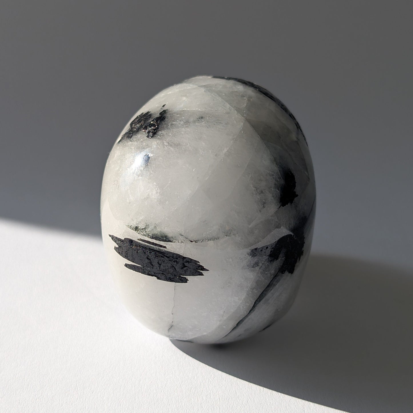 Kristallschädel "Hokan" (436g) aus klarem Quarz mit schwarzen Turmalin-Nadeln.