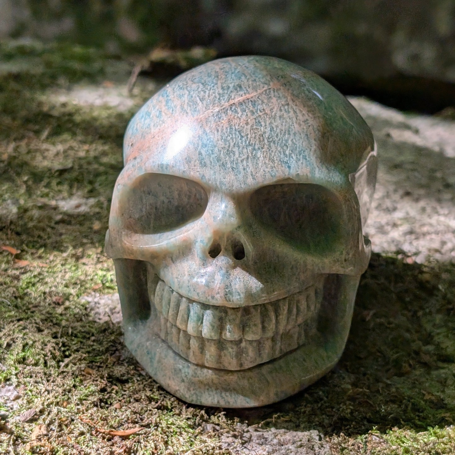 Kristallschädel "Ozeanfrieden" aus Amazonit mit blauer und grauer Maserung.