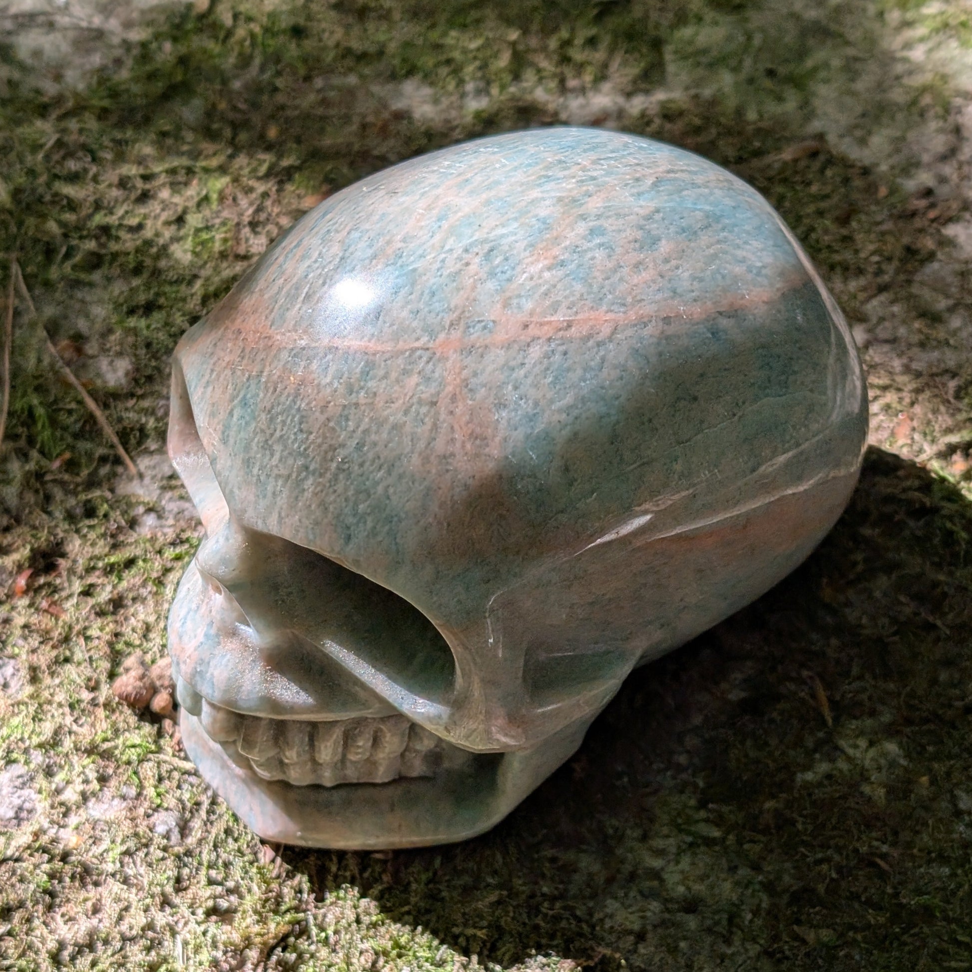 Kristallschädel "Ozeanfrieden" aus Amazonit mit blauer und grauer Maserung.