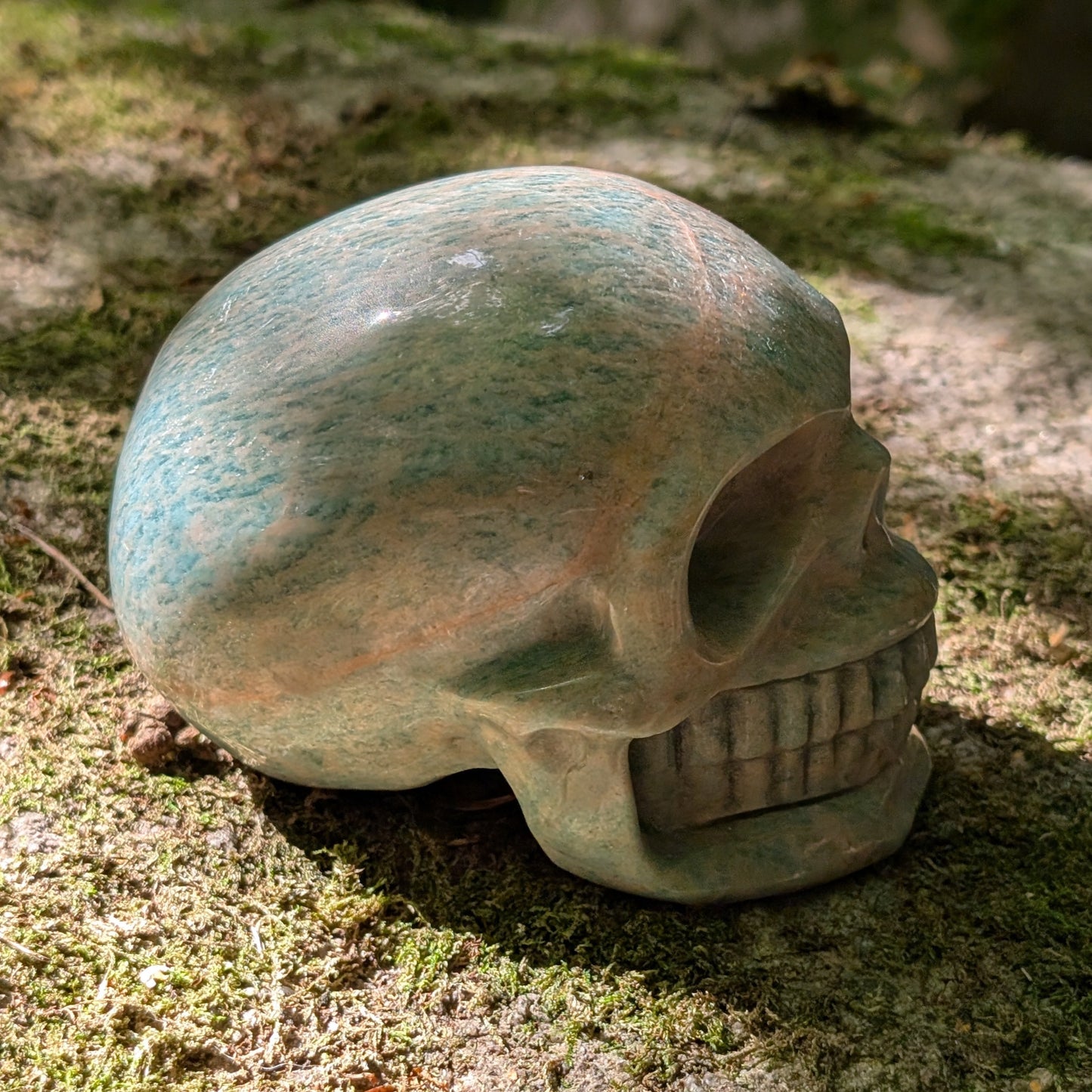 Kristallschädel "Ozeanfrieden" aus Amazonit mit blauer und grauer Maserung.