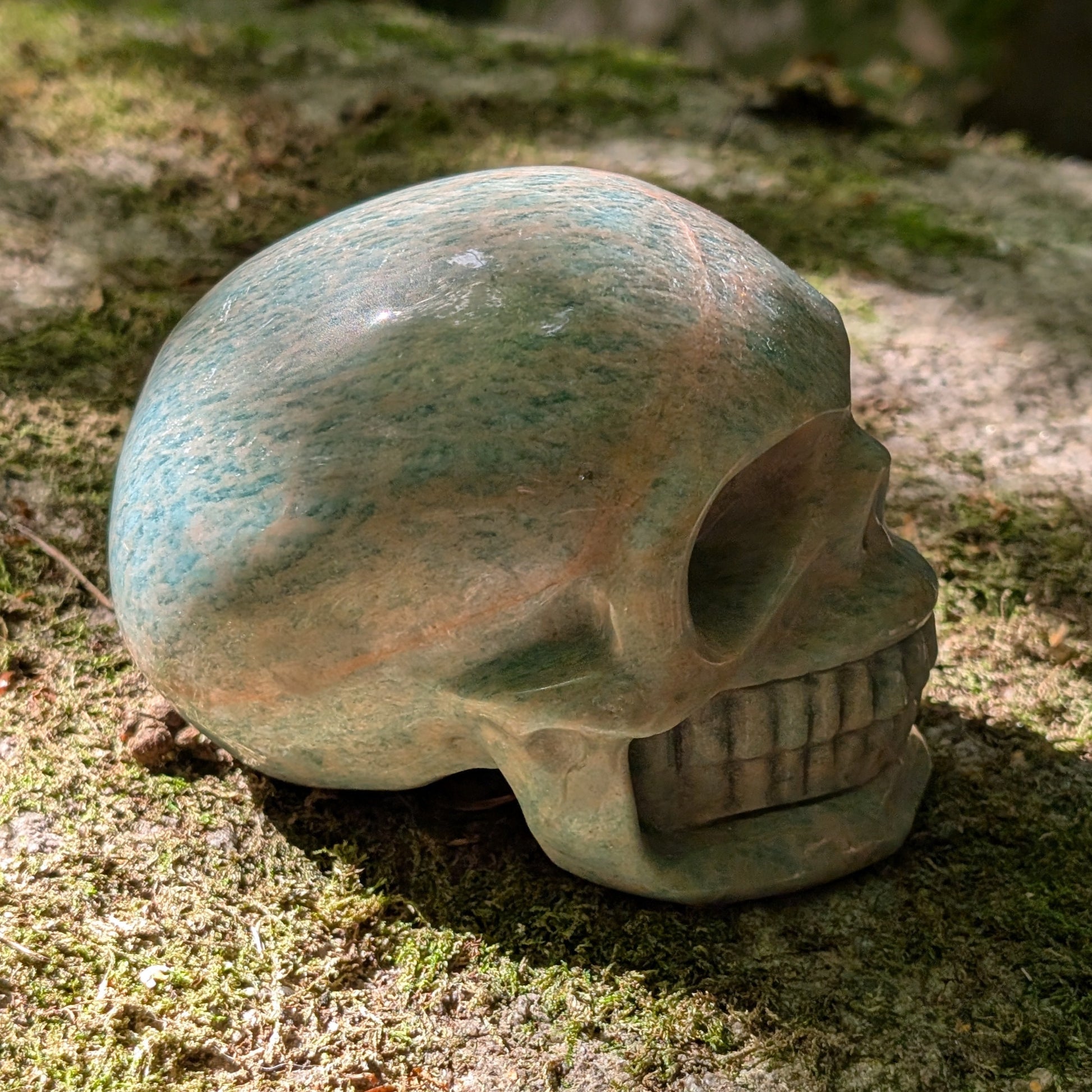 Kristallschädel "Ozeanfrieden" aus Amazonit mit blauer und grauer Maserung.