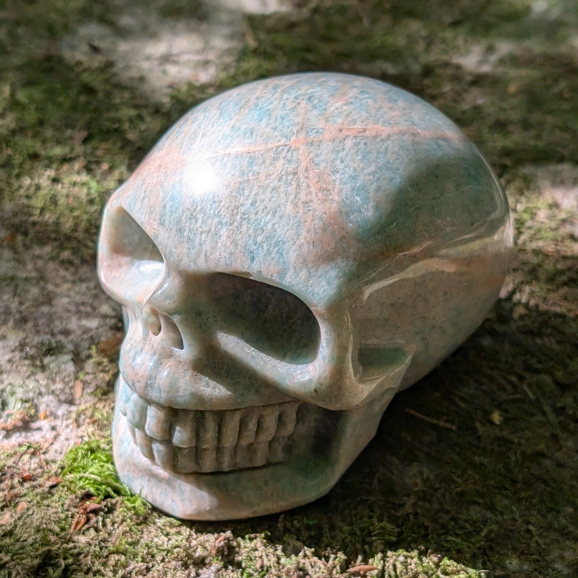 Kristallschädel "Ozeanfrieden" aus Amazonit mit blauer und grauer Maserung.