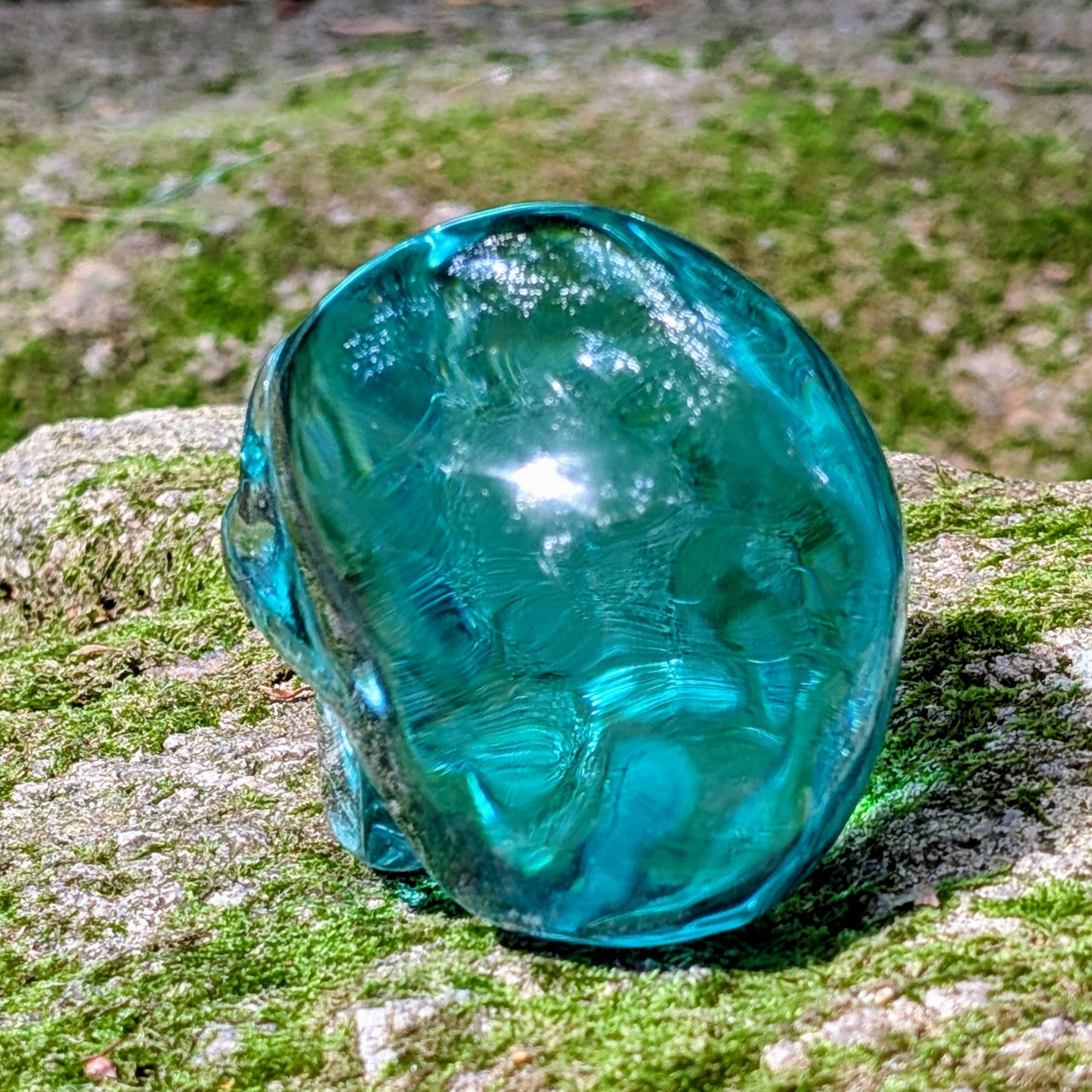 Kristallschädel "Ozeanseele" aus türkisfarbenem Quarzglas.