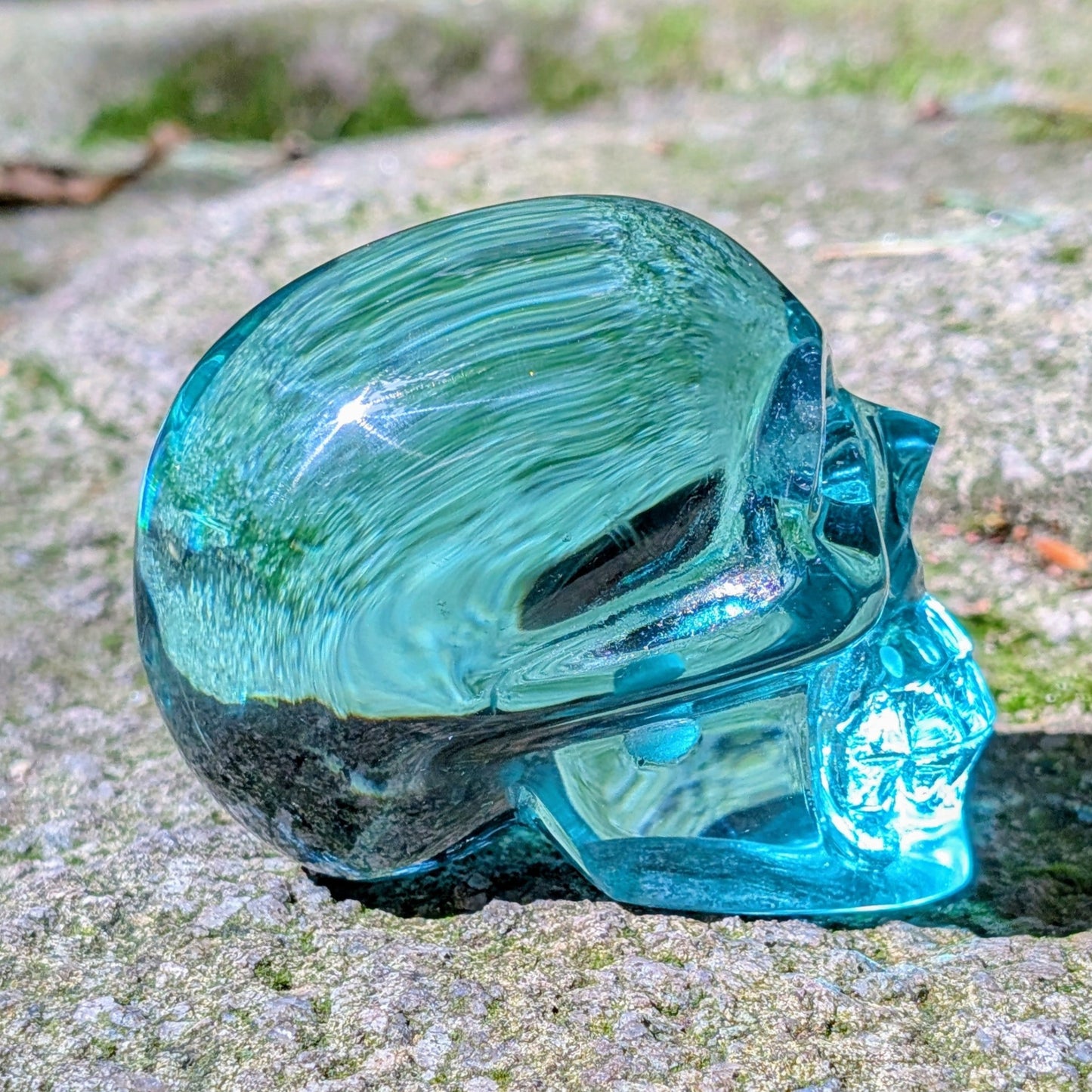 Kristallschädel "Ozeanseele" aus türkisfarbenem Quarzglas.