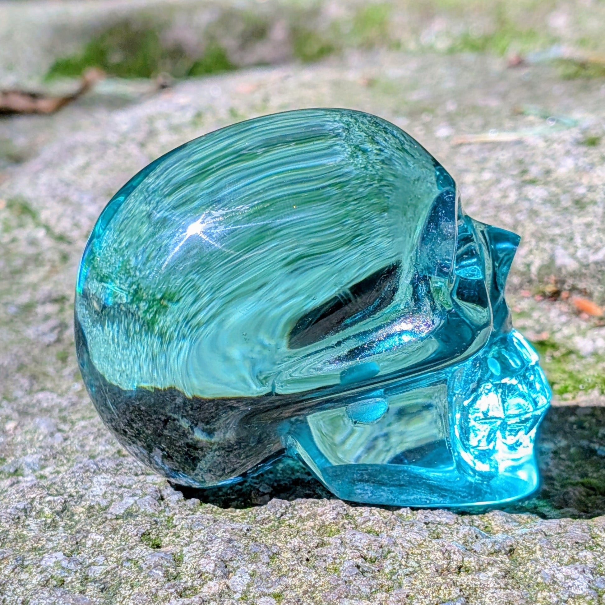 Kristallschädel "Ozeanseele" aus türkisfarbenem Quarzglas.
