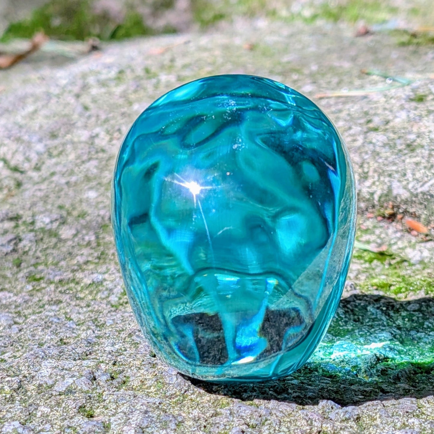 Kristallschädel "Ozeanseele" aus türkisfarbenem Quarzglas.