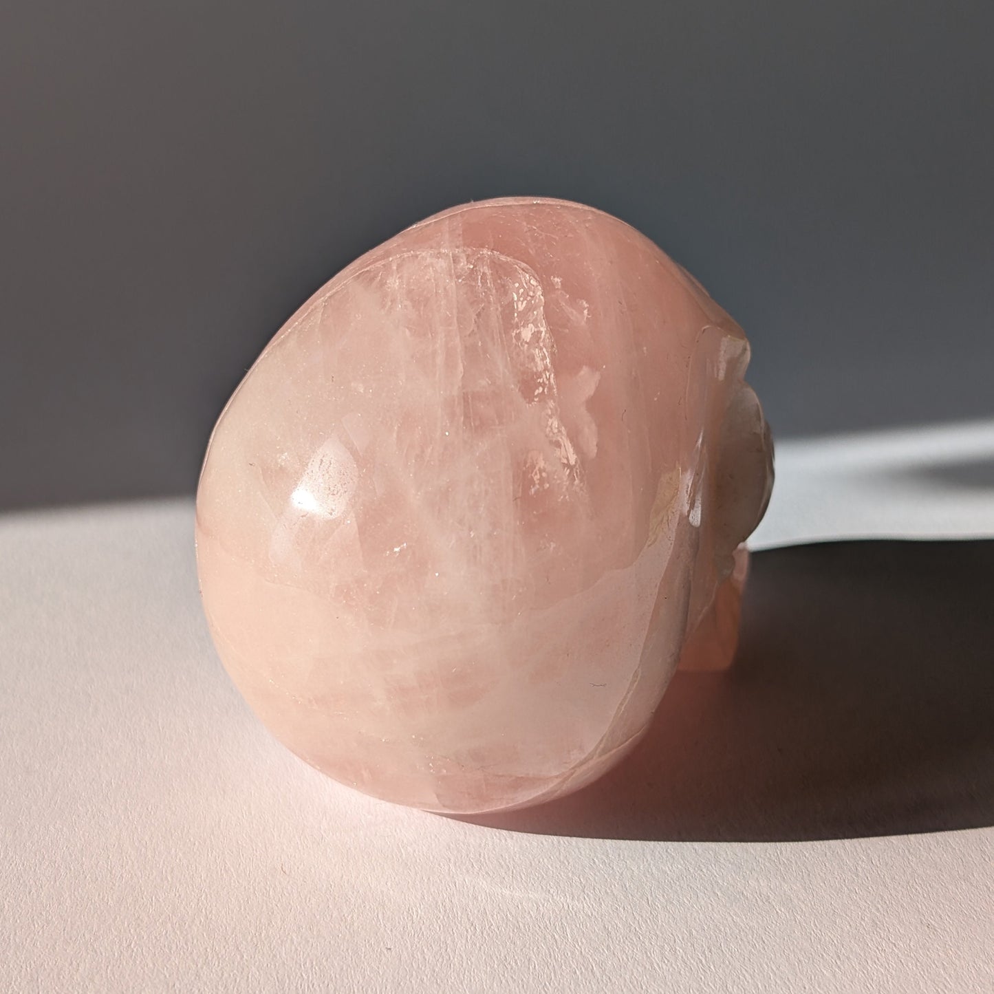 Kristallschädel "Sairun" (434g) aus zartrosa Rosenquarz im Seitenprofil.