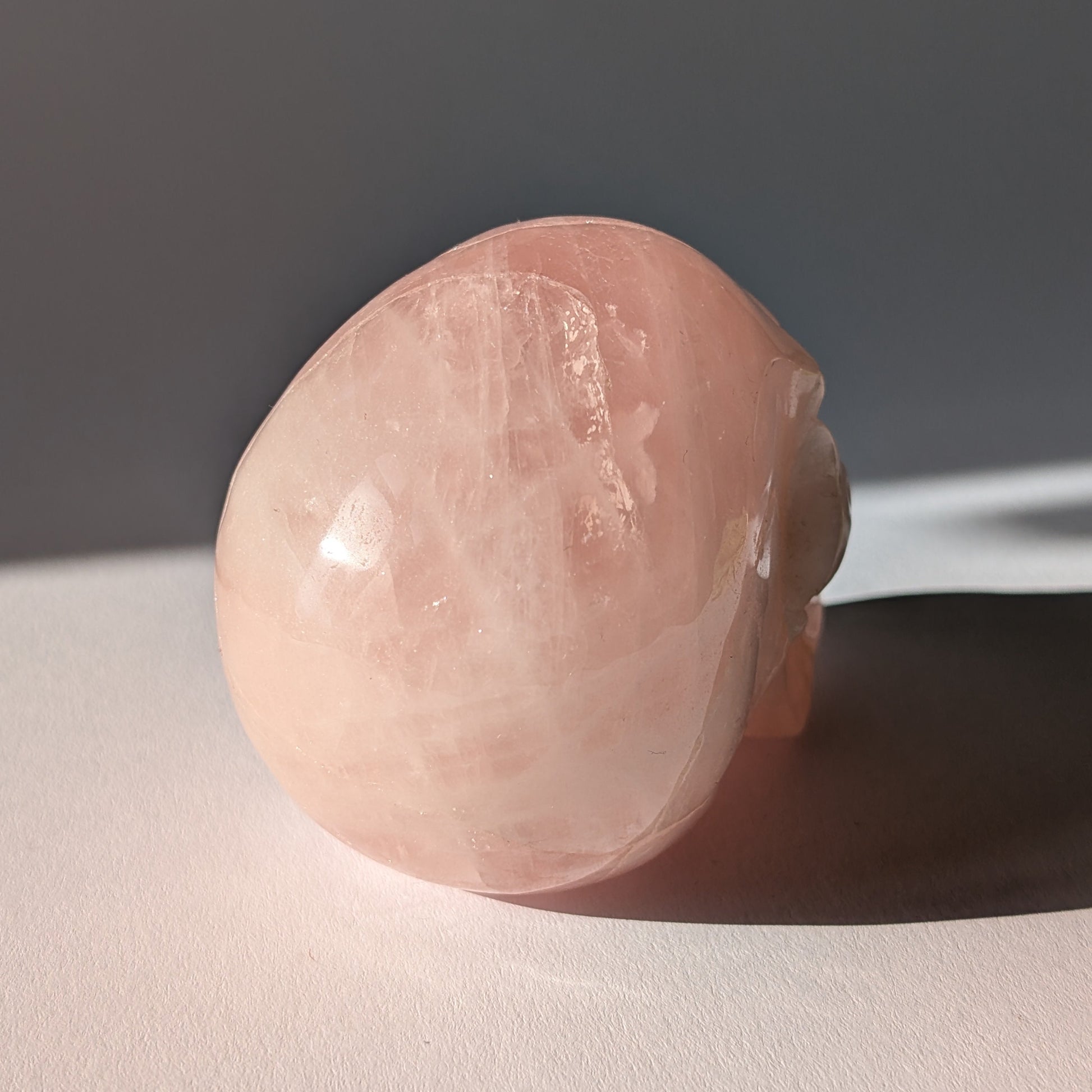 Kristallschädel "Sairun" (434g) aus zartrosa Rosenquarz im Seitenprofil.