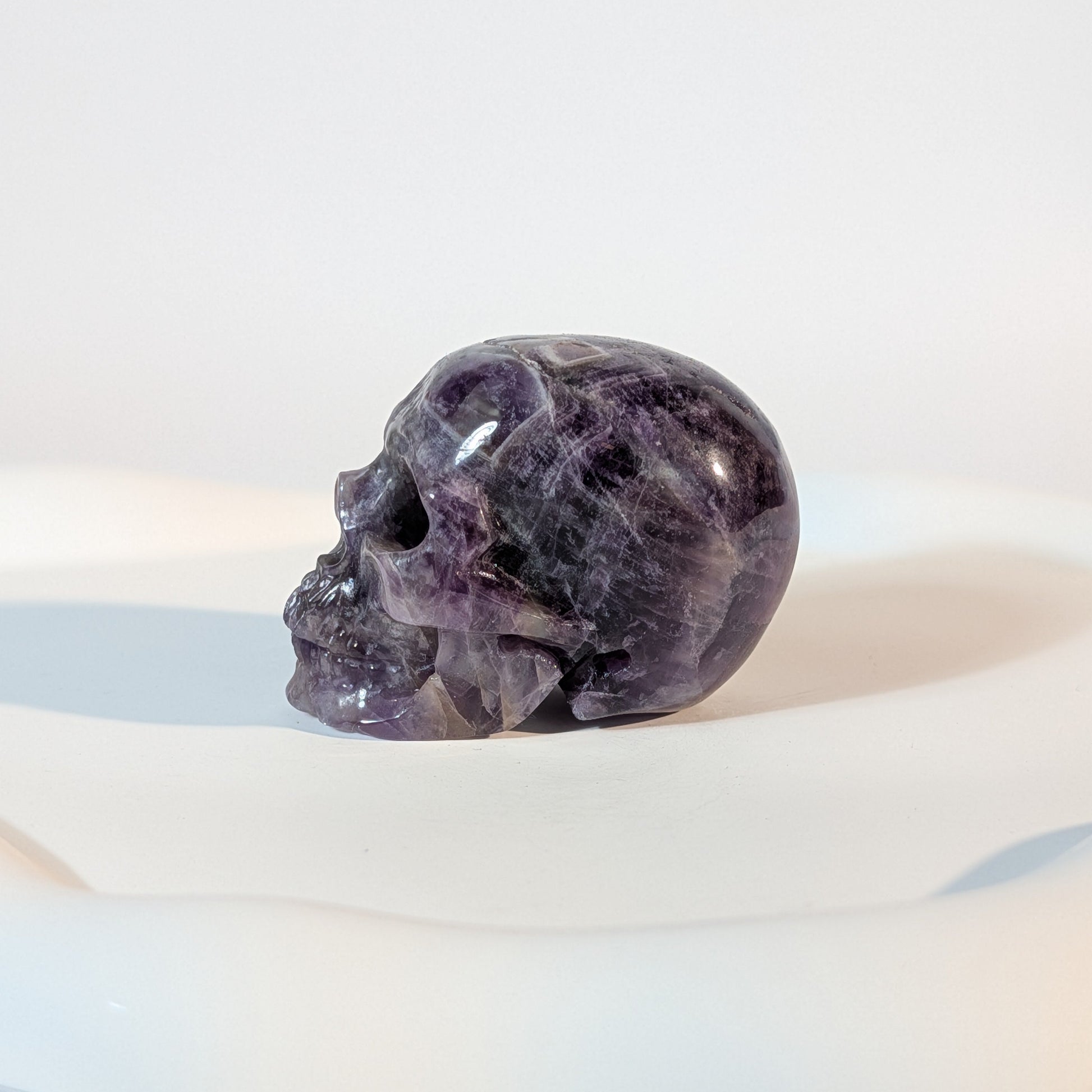 Kristallschädel Sartarius aus violettem Amethyst mit lichtdurchlässigen Zonen und sanften weißen Quarz-Strukturen.