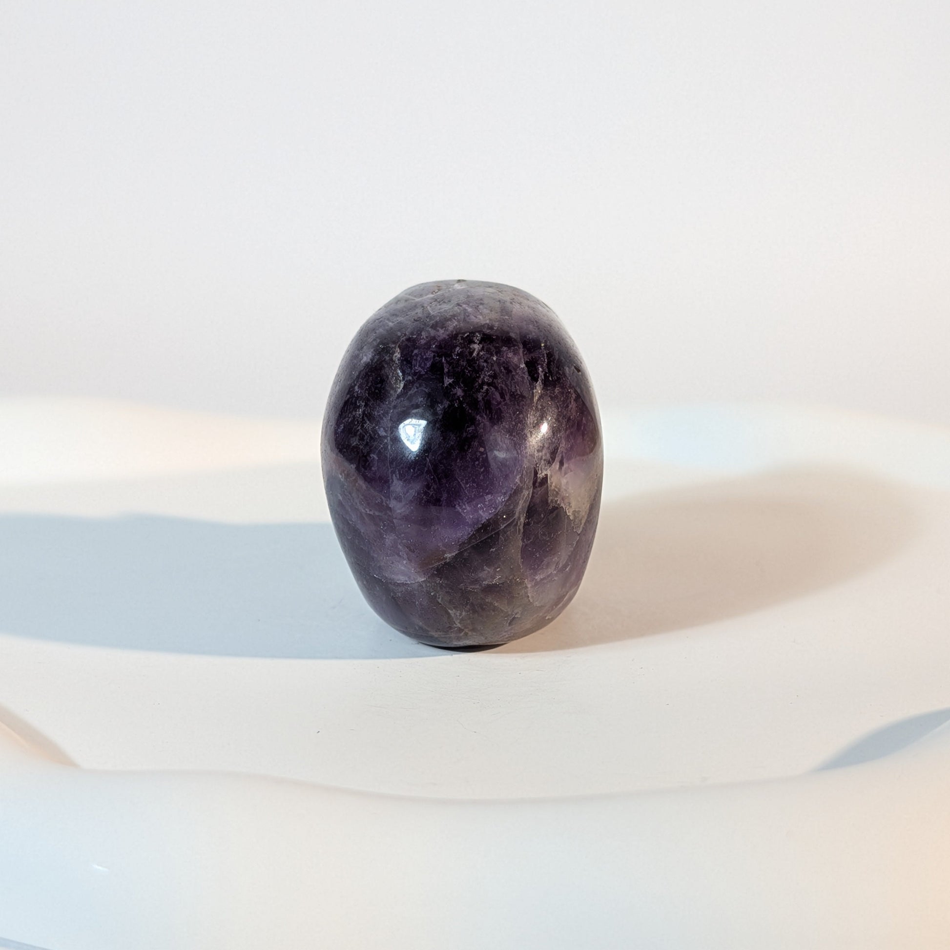 Kristallschädel Sartarius aus violettem Amethyst mit lichtdurchlässigen Zonen und sanften weißen Quarz-Strukturen.
