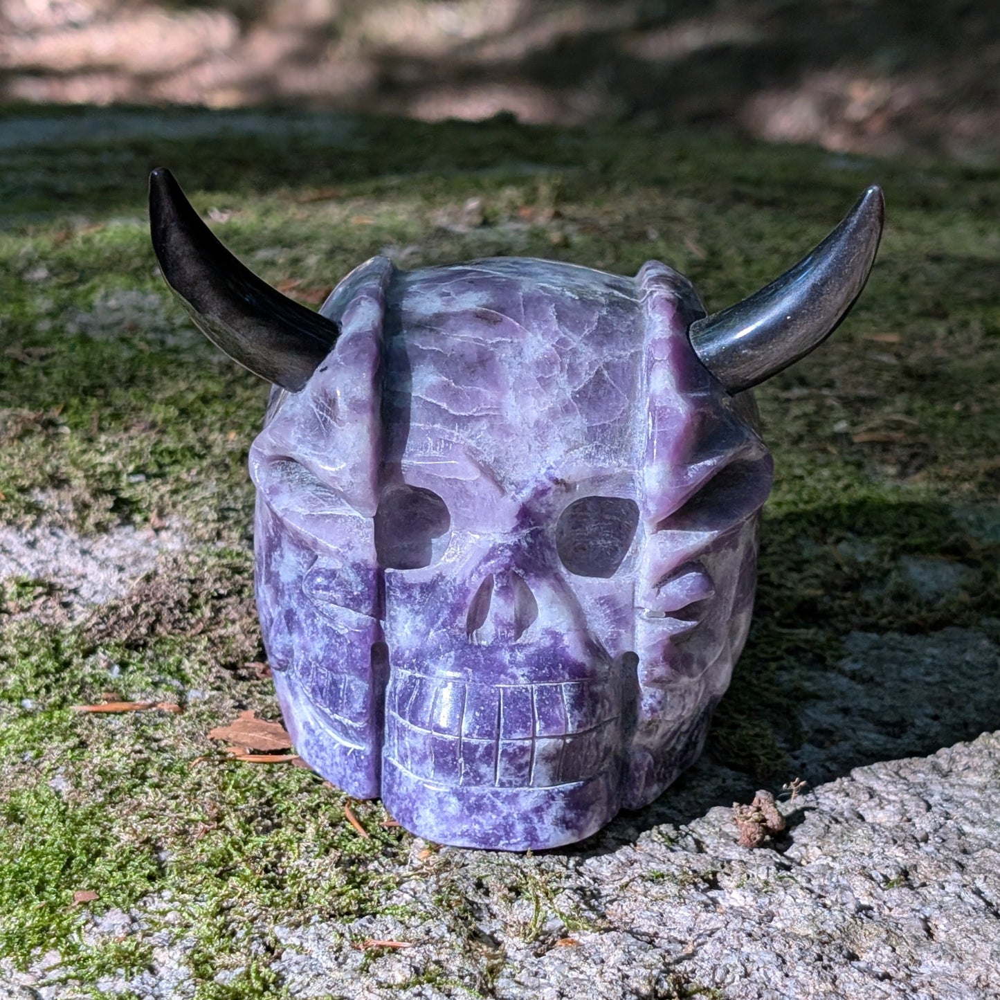 Kristallschädel "Schattenfürst" aus Amethyst mit schwarzen Obsidian-Hörnern.